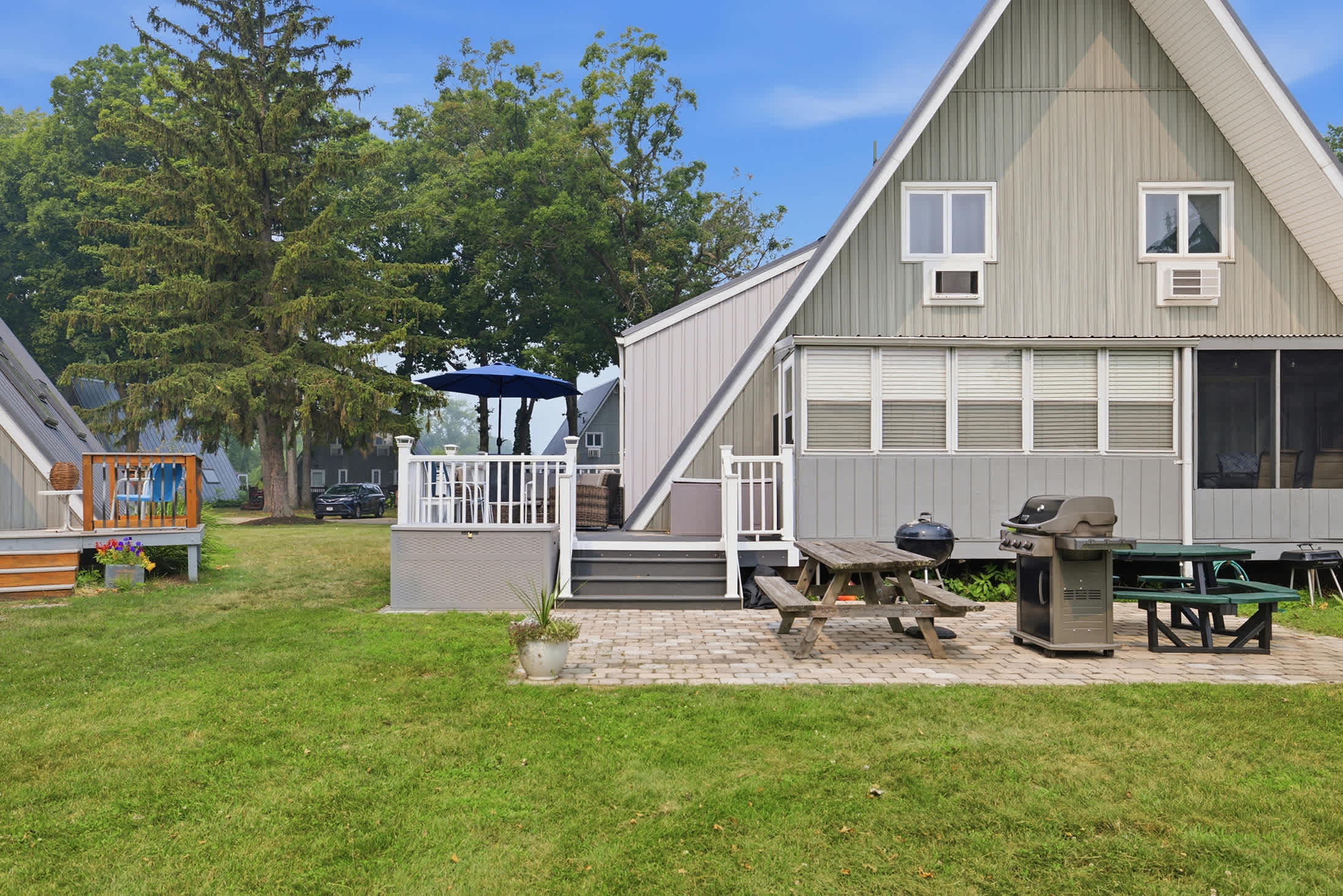 Outdoor living includes a furnished deck, picnic table, and dual BBQ grills.