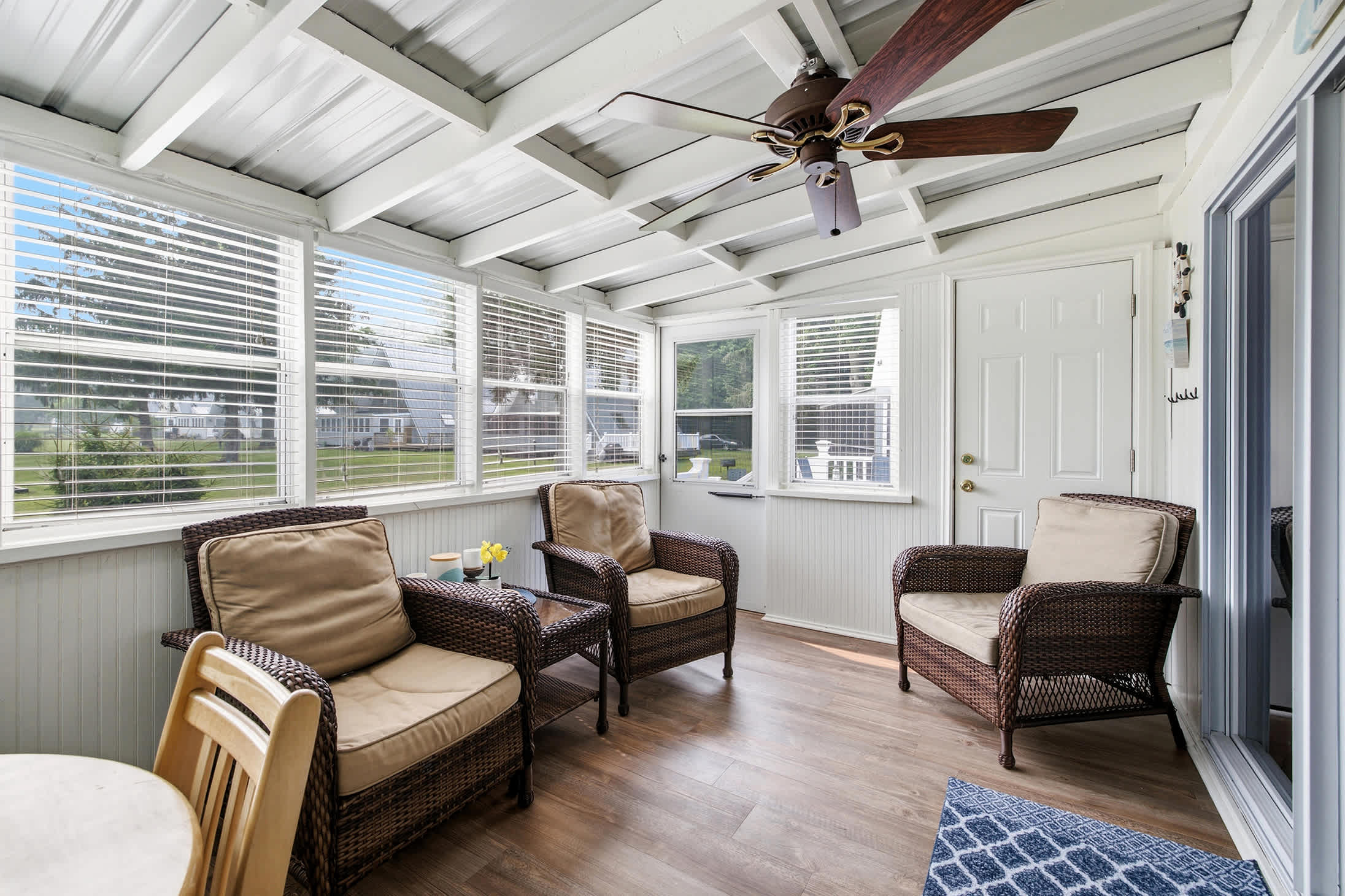 Enclosed porch adds a second living area with comfortable seating and views.