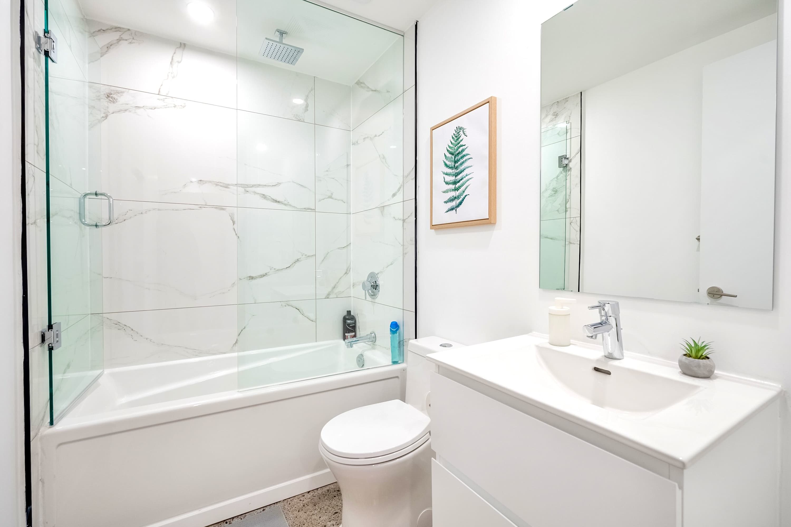 Clean vanity with deep soaking tub and glass shower for complete relaxation.