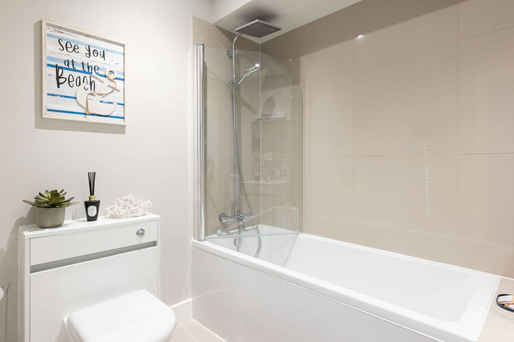 Bright family bathroom with shower over bath, perfect for relaxing after beach adventures