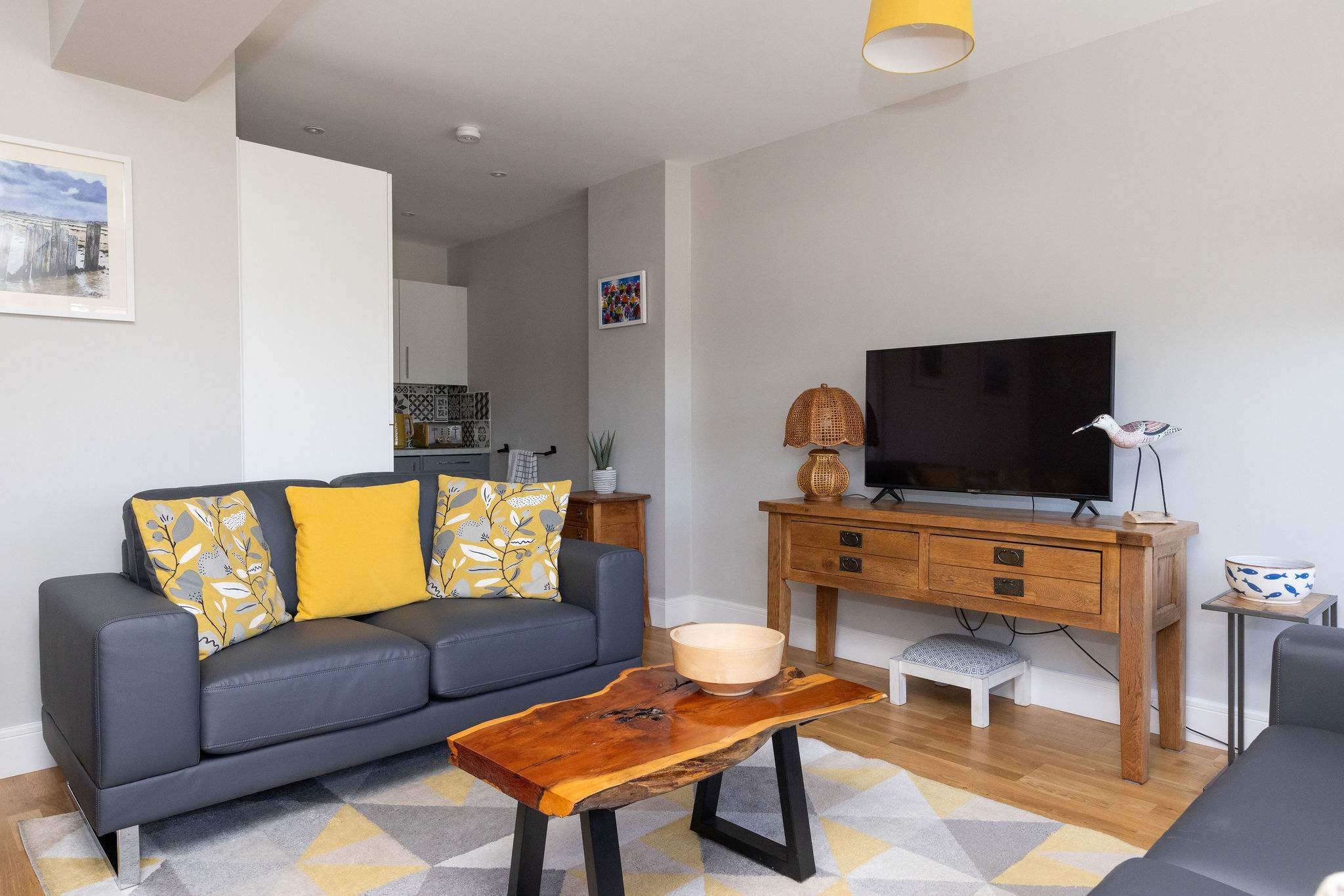 Bright open-plan lounge with comfortable seating, perfect for a relaxing coastal holiday home