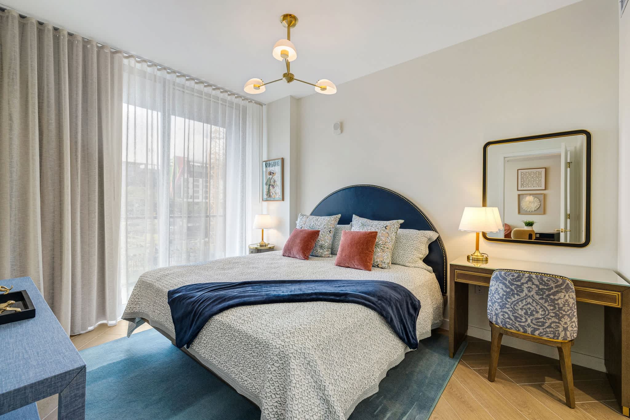 Relax in this beautifully designed bedroom with a plush bed, elegant desk, and ample natural light.