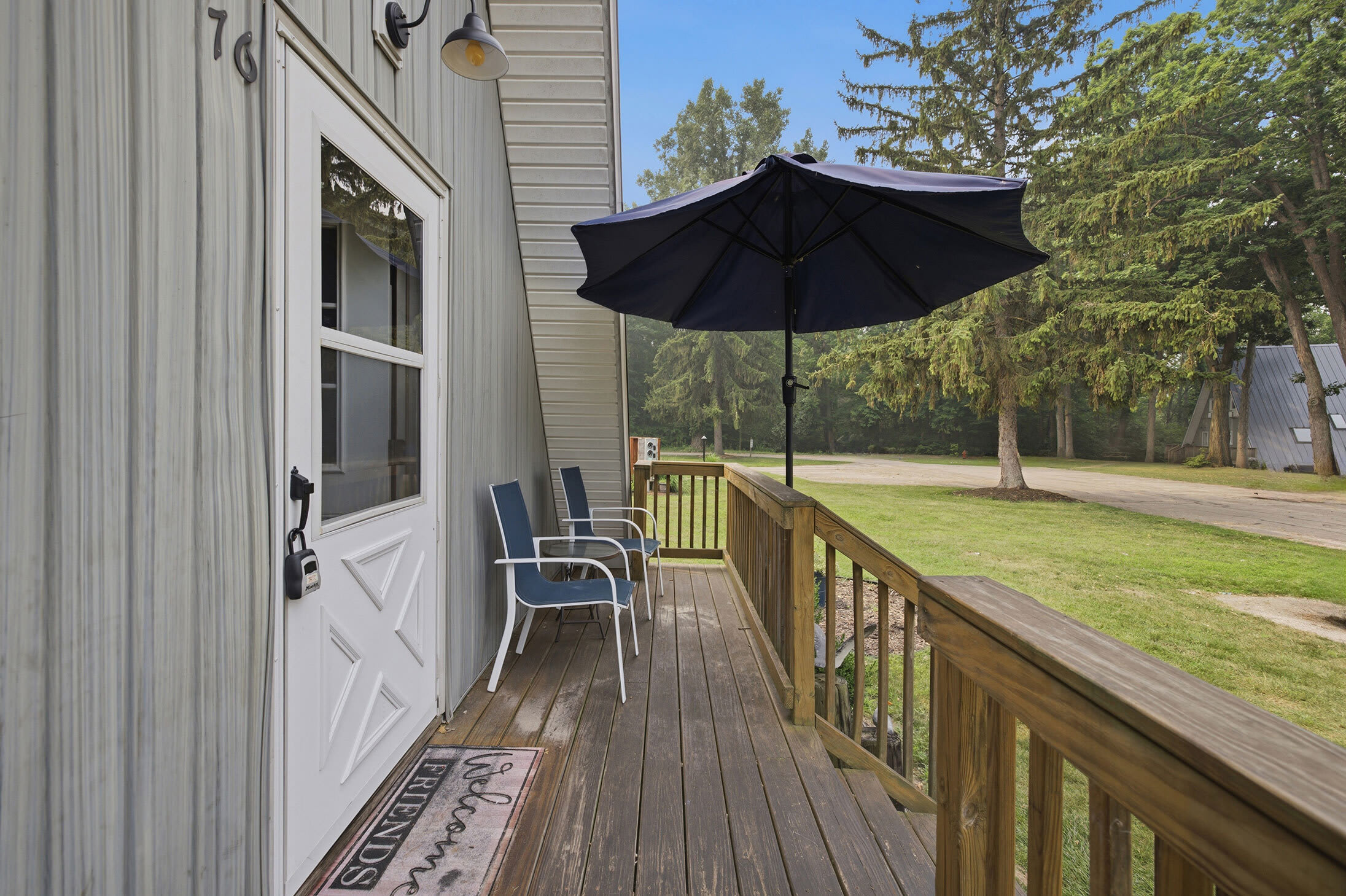 Chalet #76 welcomes guests with a front deck and comfortable outdoor chairs.