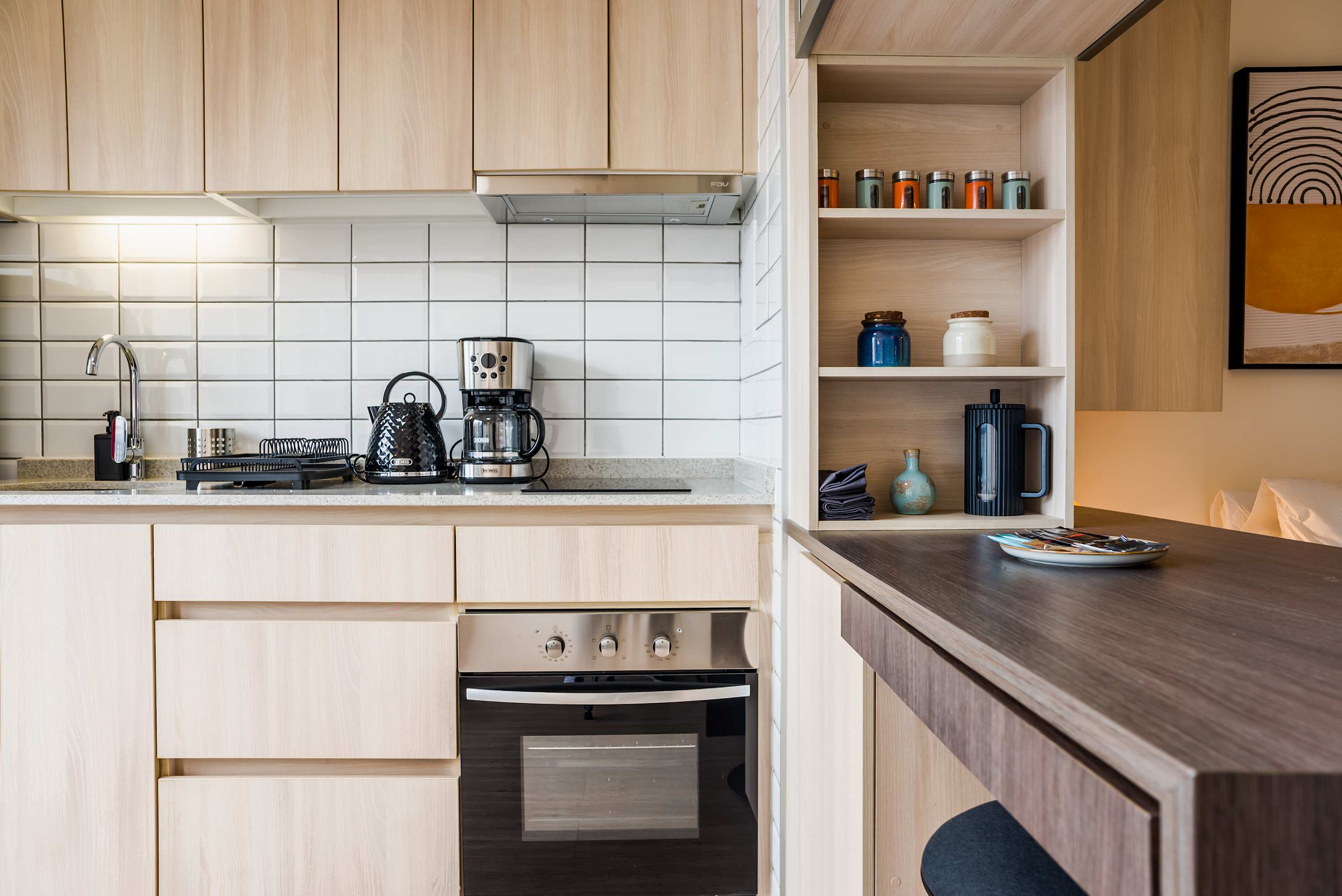 Stylish and efficient kitchen with modern appliances and chic open shelving, perfect for preparing meals in comfort.