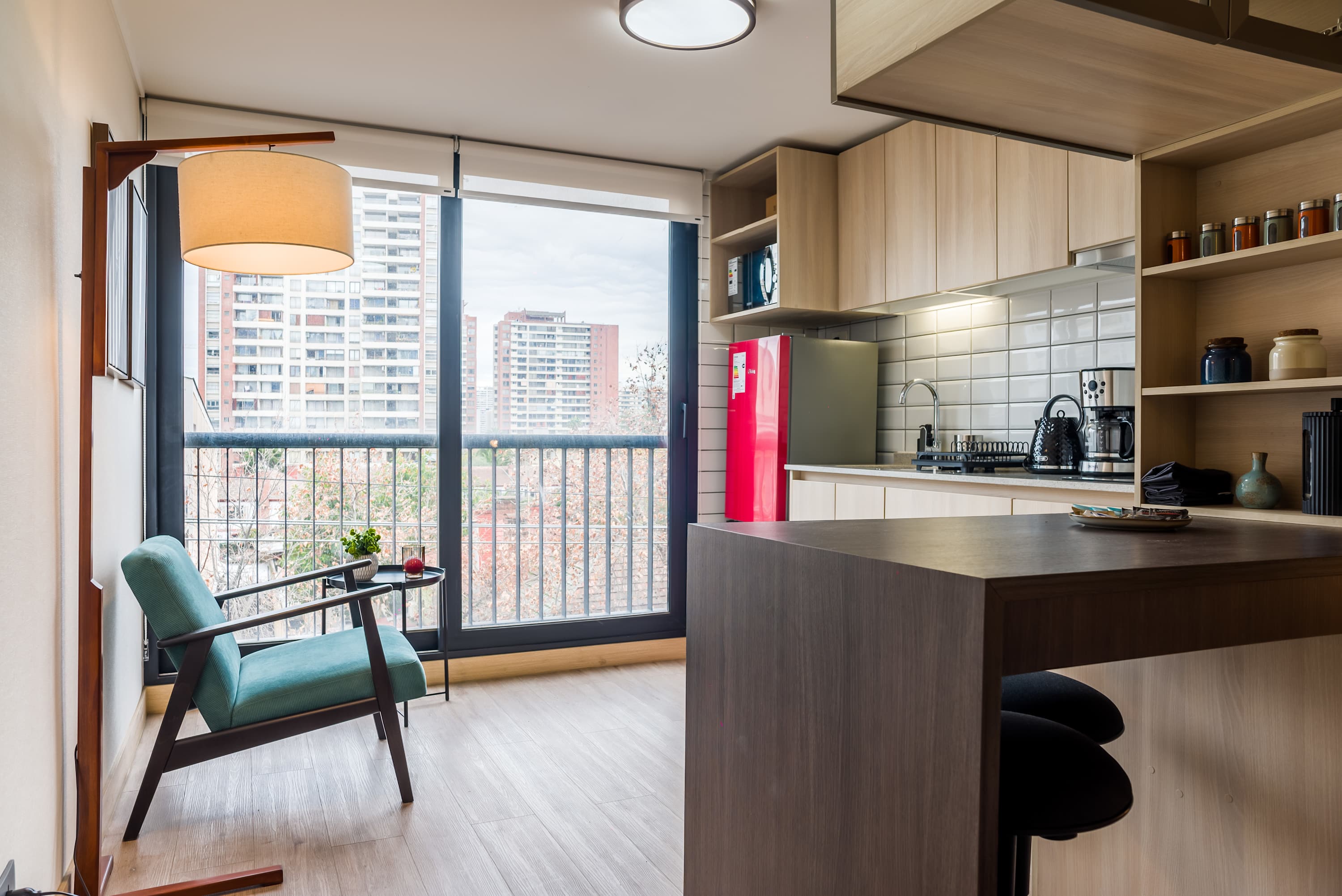 Bright and modern living space with a stunning city view and a stylish kitchen, perfect for a cozy stay in the heart of the city.