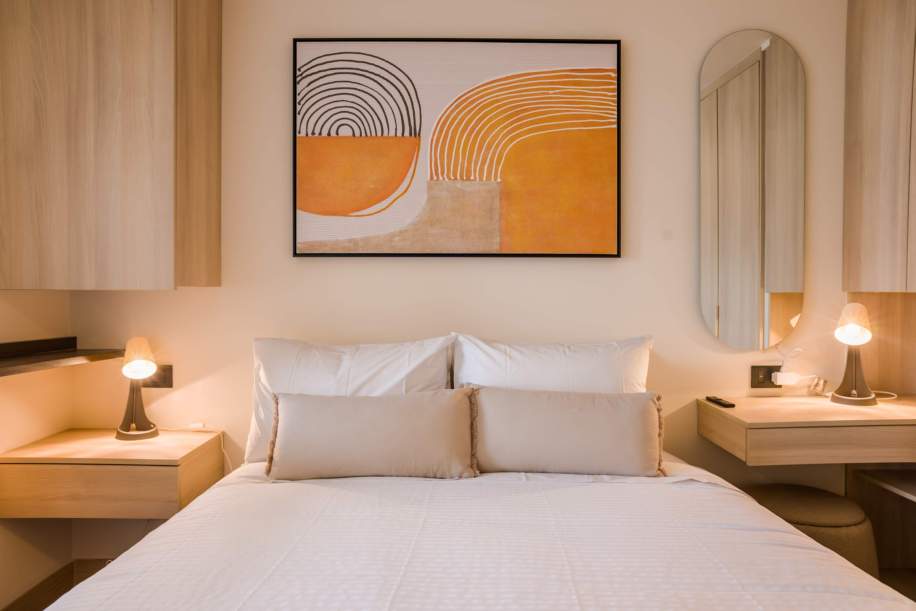 Cozy bedroom with modern decor and warm lighting, perfect for a relaxing stay.