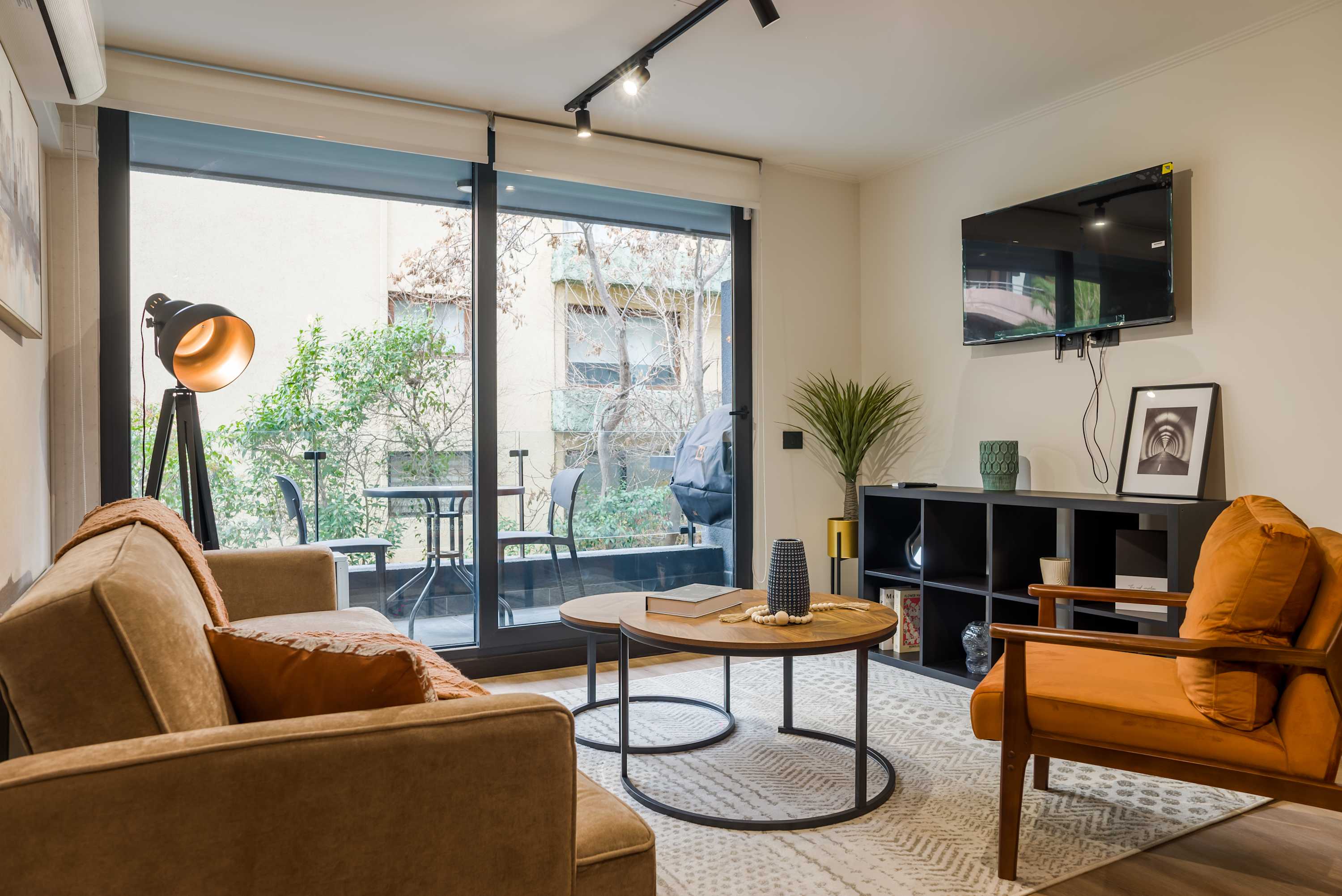 Relax in this cozy living room with a view of the balcony, perfect for unwinding after a day of exploring.