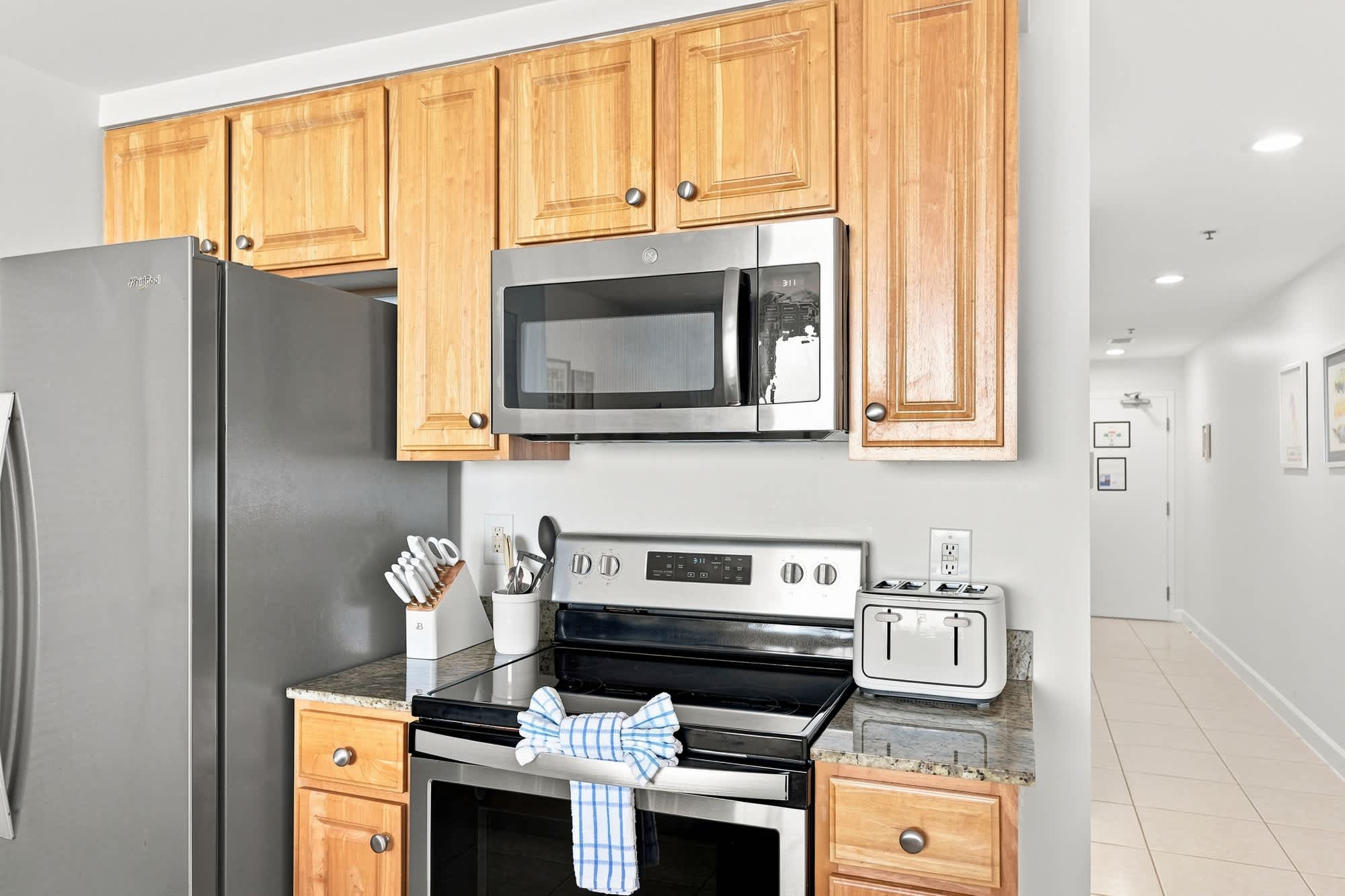 Splash 804E – Modern kitchen with stainless steel appliances, wood cabinets, and a granite countertop.