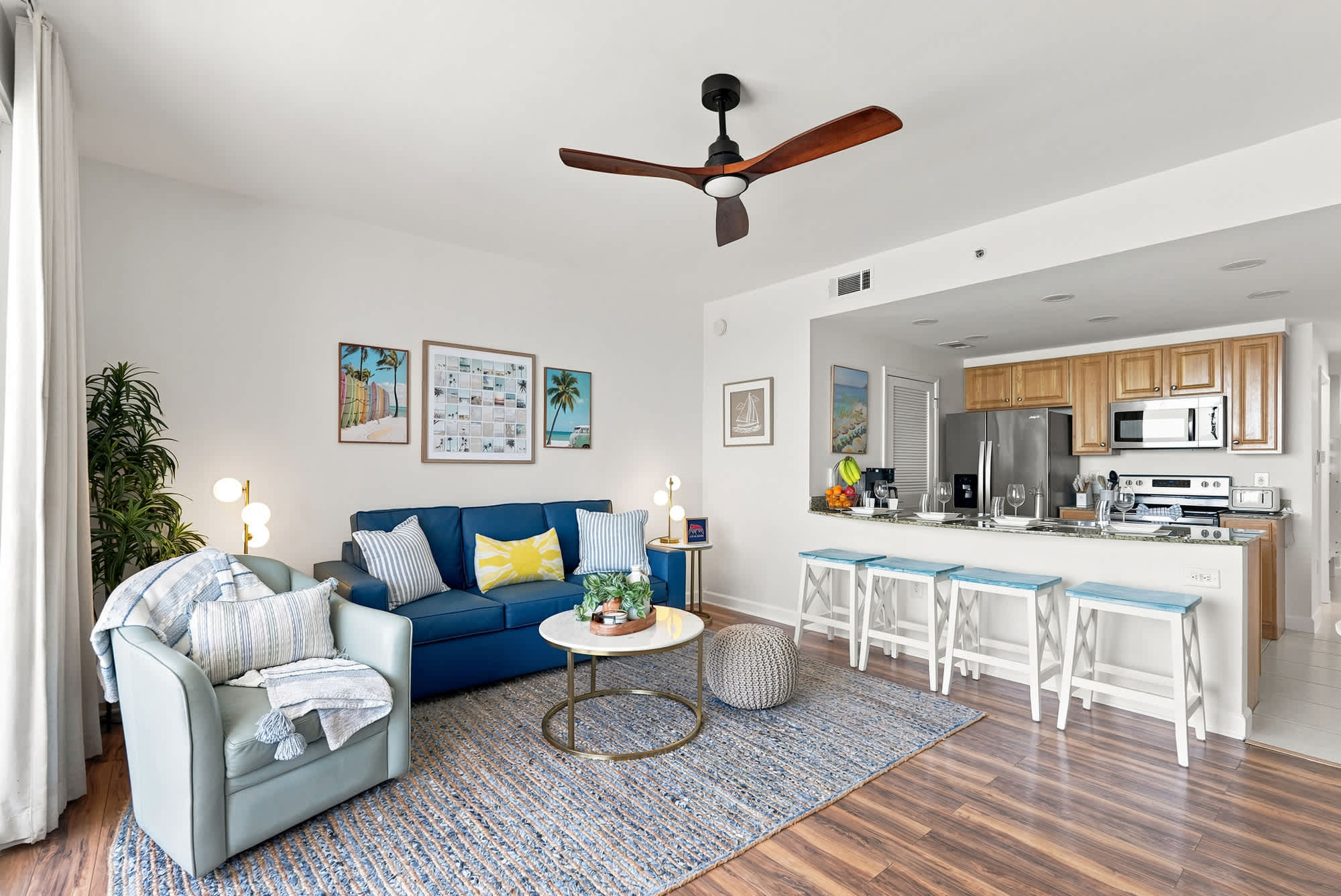 Splash 804E – Living room with blue sofa, light wood accents, kitchen area, and a view of decorative artwork.