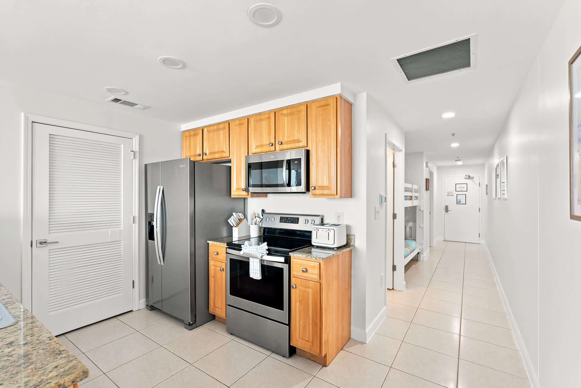 Splash 804E – Kitchen area with stainless steel appliances, granite countertops, and a hallway leading to a bunk bed room.