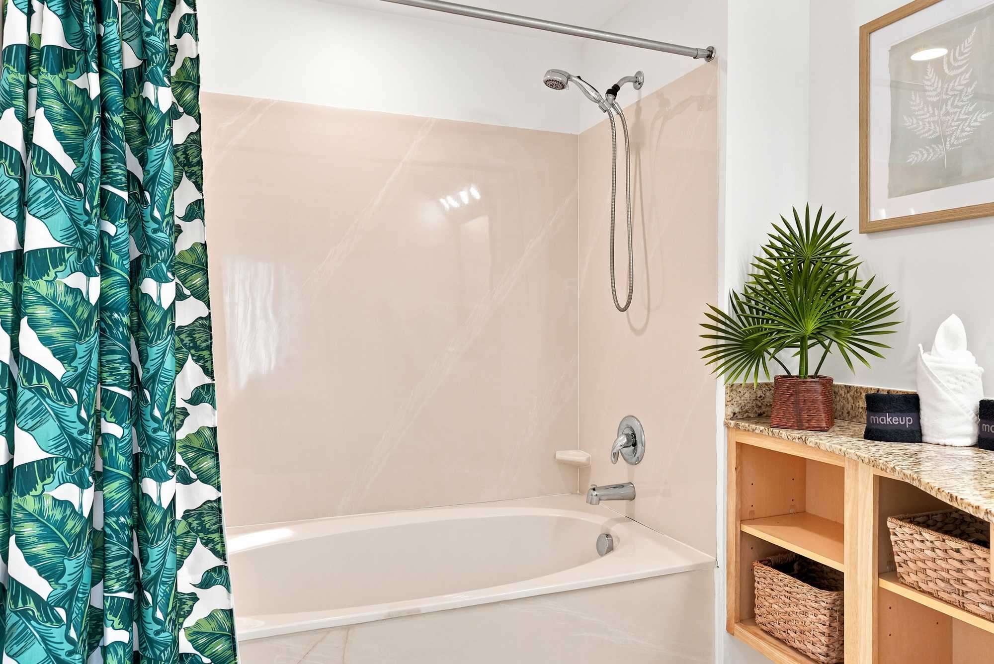 Splash 804E – Modern bathroom featuring a bathtub, shower, tropical-patterned curtain, stone countertop, and decorative plant.