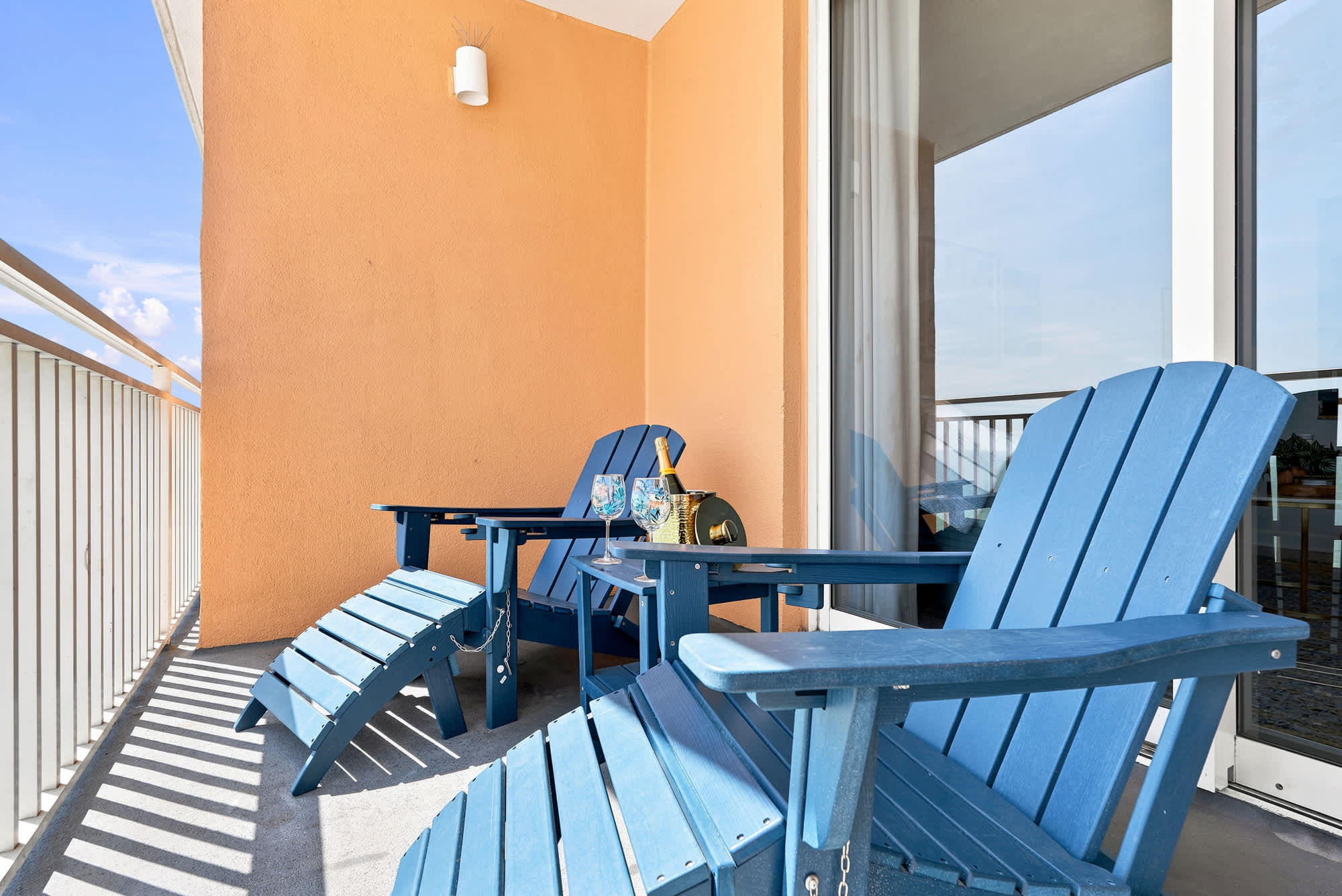 Splash 804E – Balcony with two blue chairs, a small table, and views of the sky and beach.