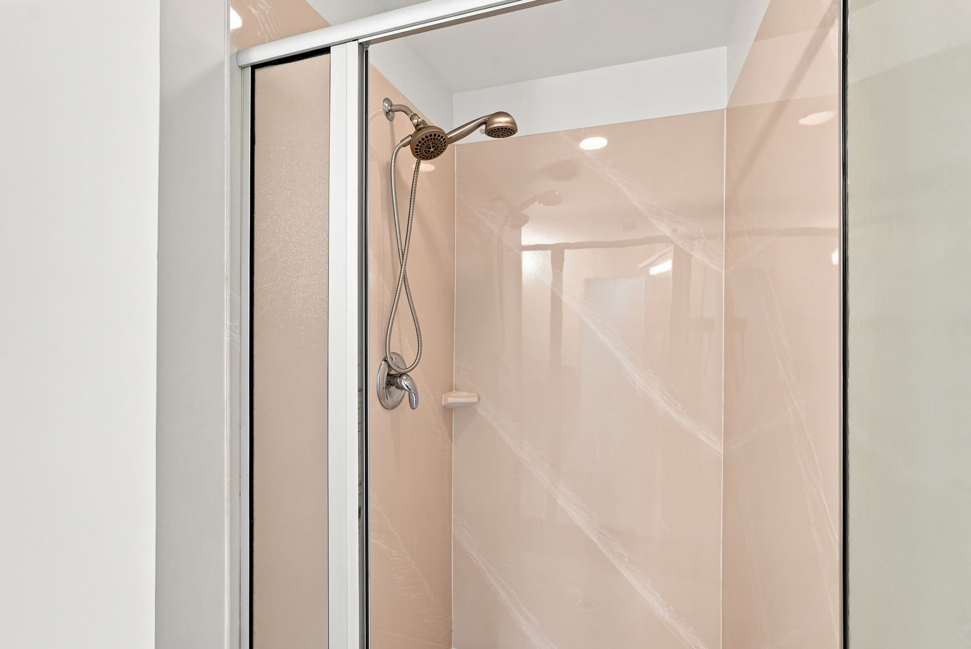 Splash 804E – Shower enclosure with sliding glass doors and modern fixtures, featuring light pink walls.