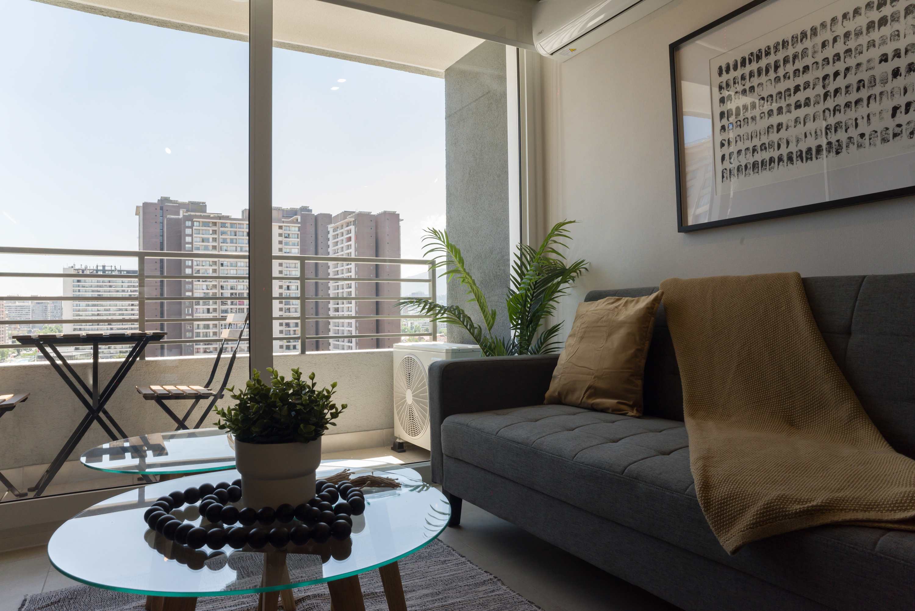 Relax in a stylish living area with city views and a cozy balcony perfect for morning coffee.