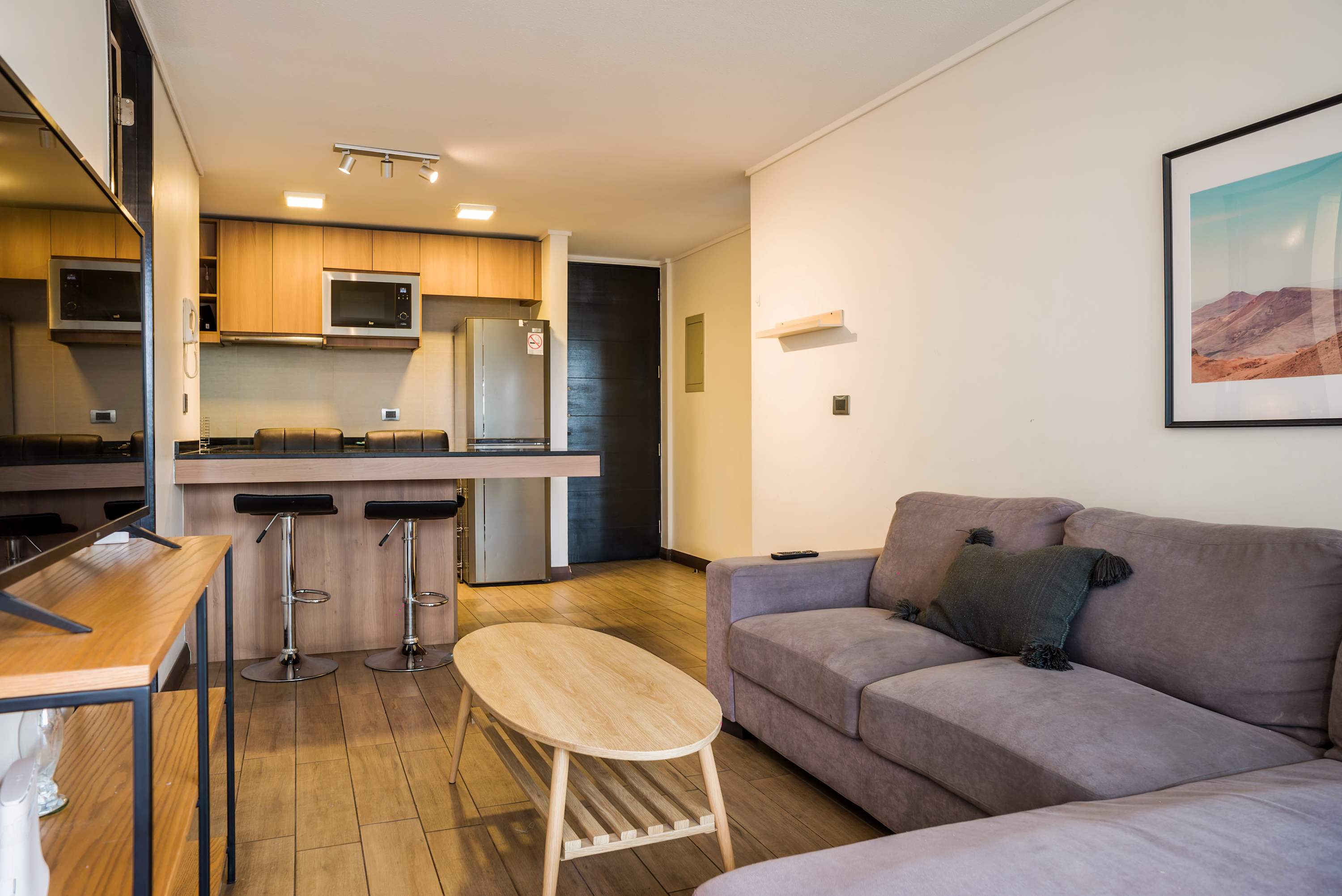 Modern living area with cozy seating and a sleek kitchen bar, perfect for relaxing after exploring the city.