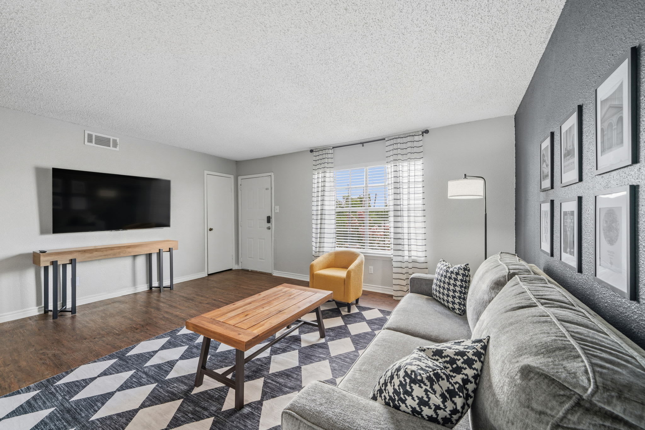 Unwind in this chic living room featuring a cozy sofa, modern decor, and a large TV for your entertainment.