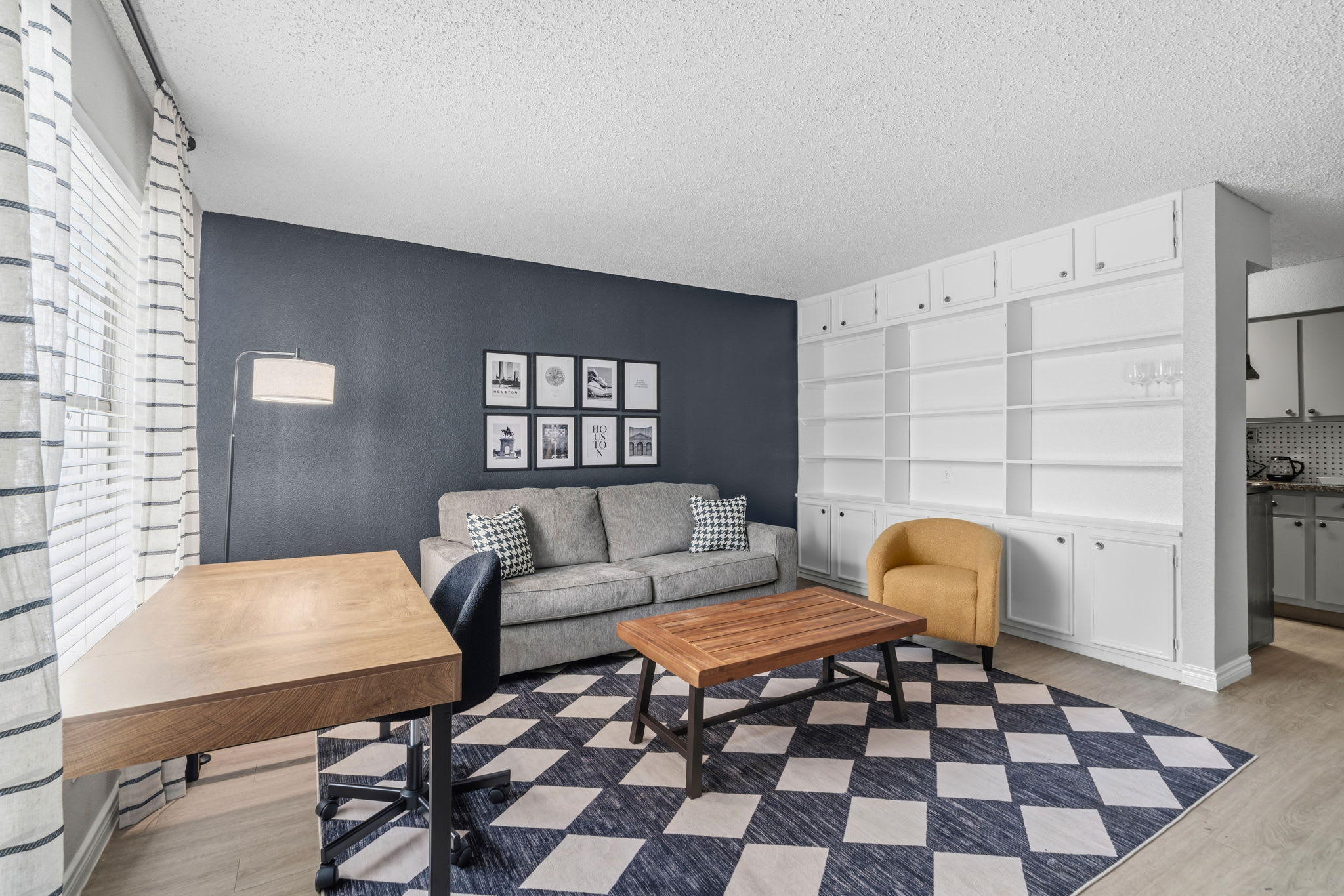 Cozy living area with stylish decor, perfect for relaxation or work, featuring ample natural light and modern furnishings.