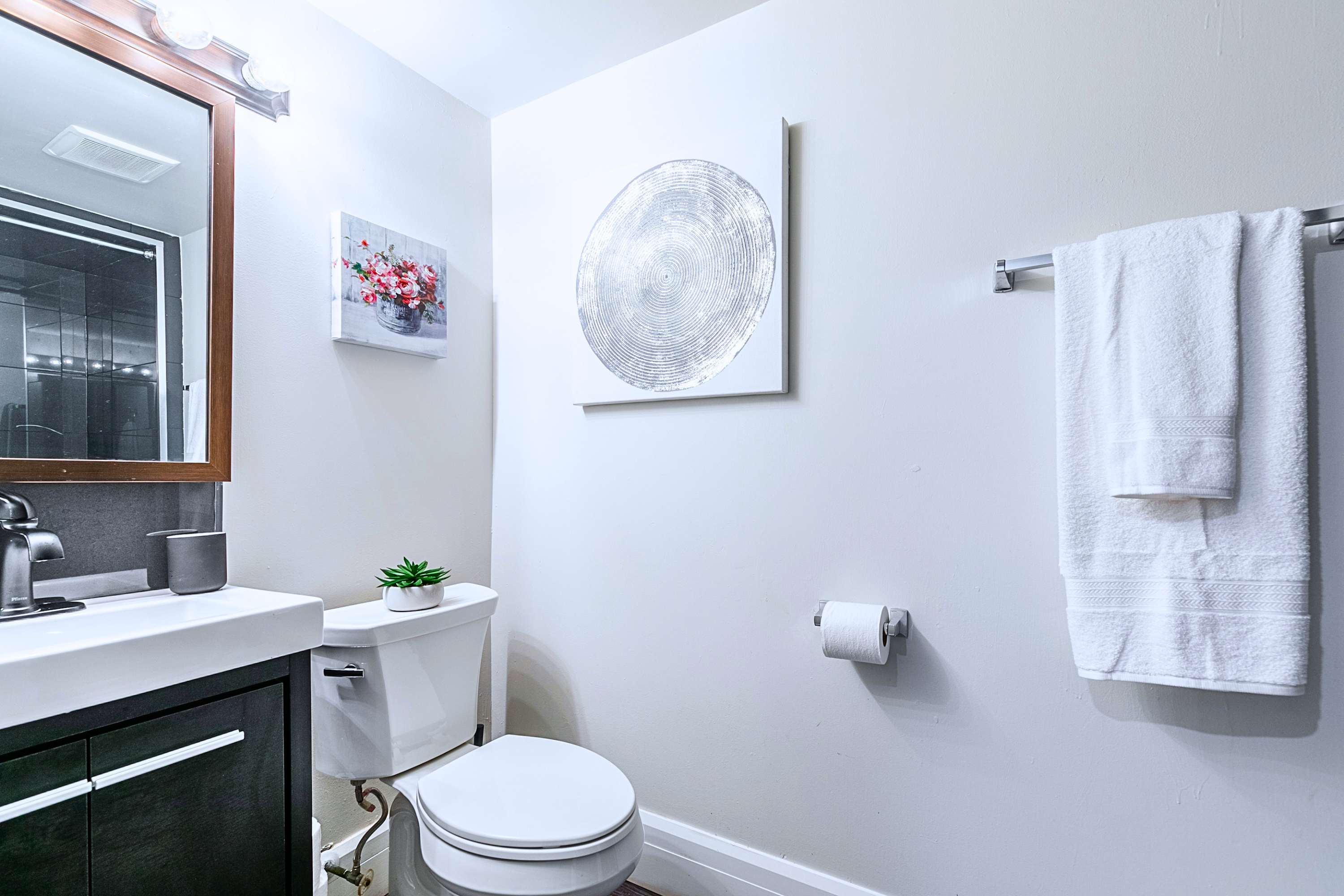 Clean Bathroom Area With Sink, Mirror & Toilet