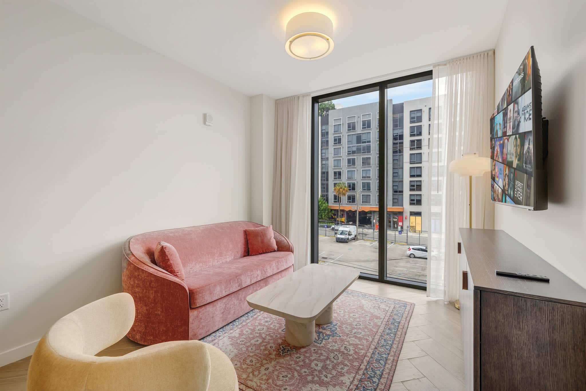 Relax in this stylish living room with a plush sofa and city views, perfect for unwinding after a day of exploring.