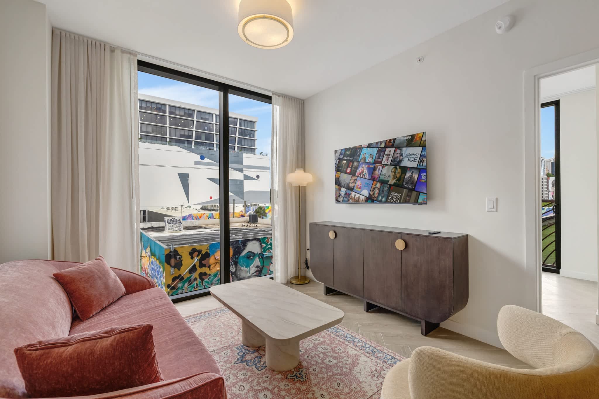 Stylish living area with modern decor and vibrant urban views through large windows.