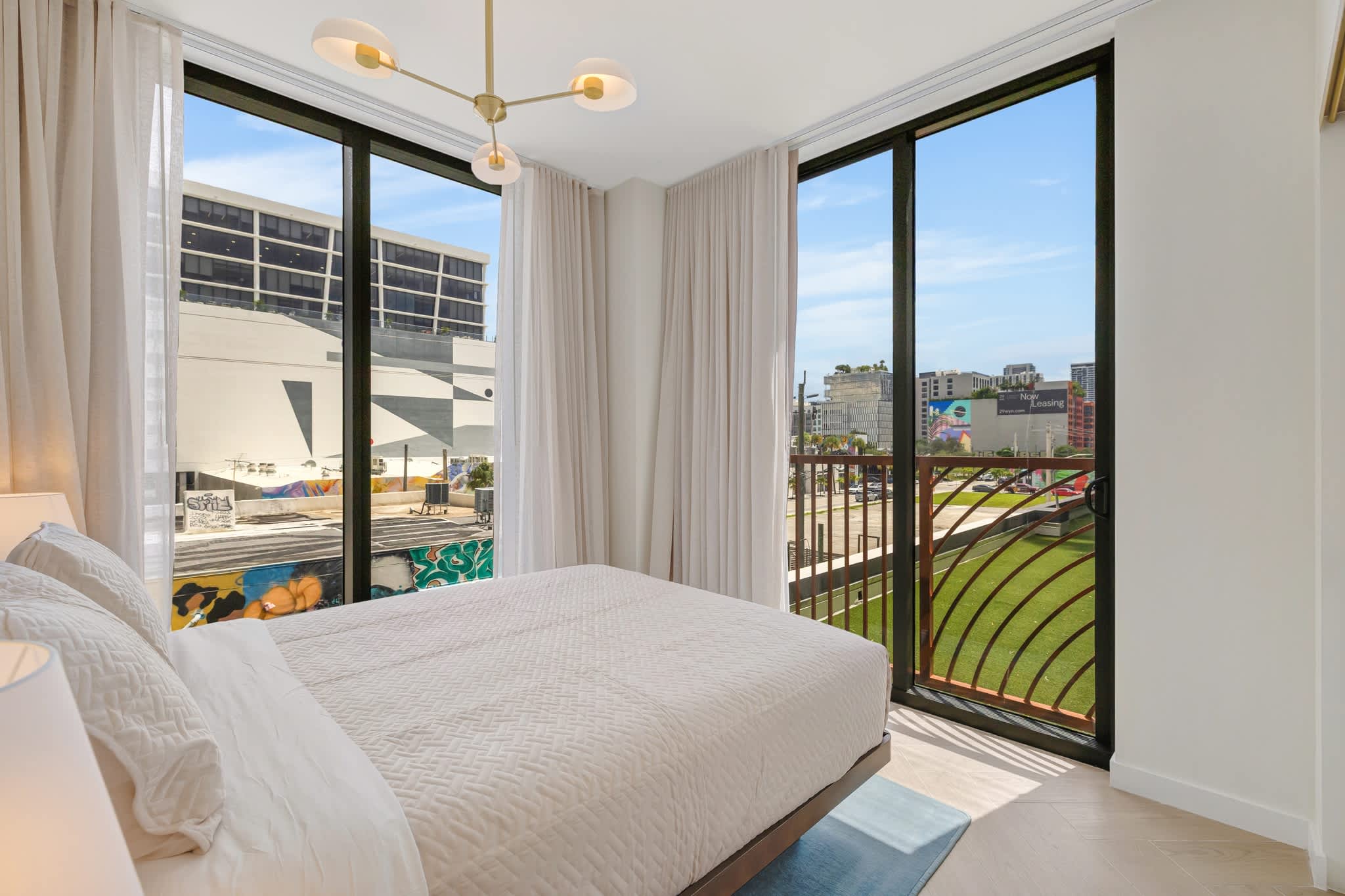Relax in this bright bedroom with stunning city views and modern decor.