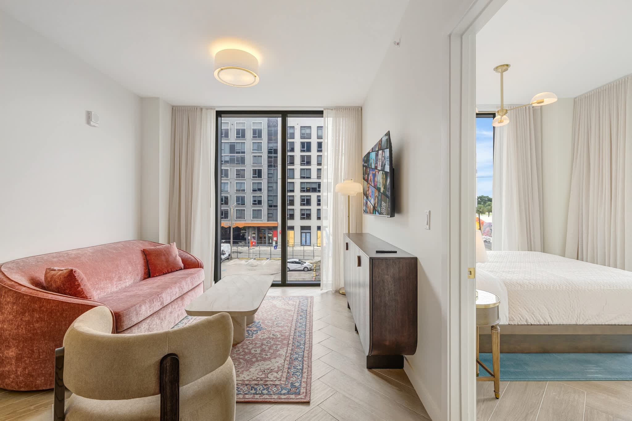 Bright and modern living area with plush seating and a large TV, perfect for relaxation after exploring the city.