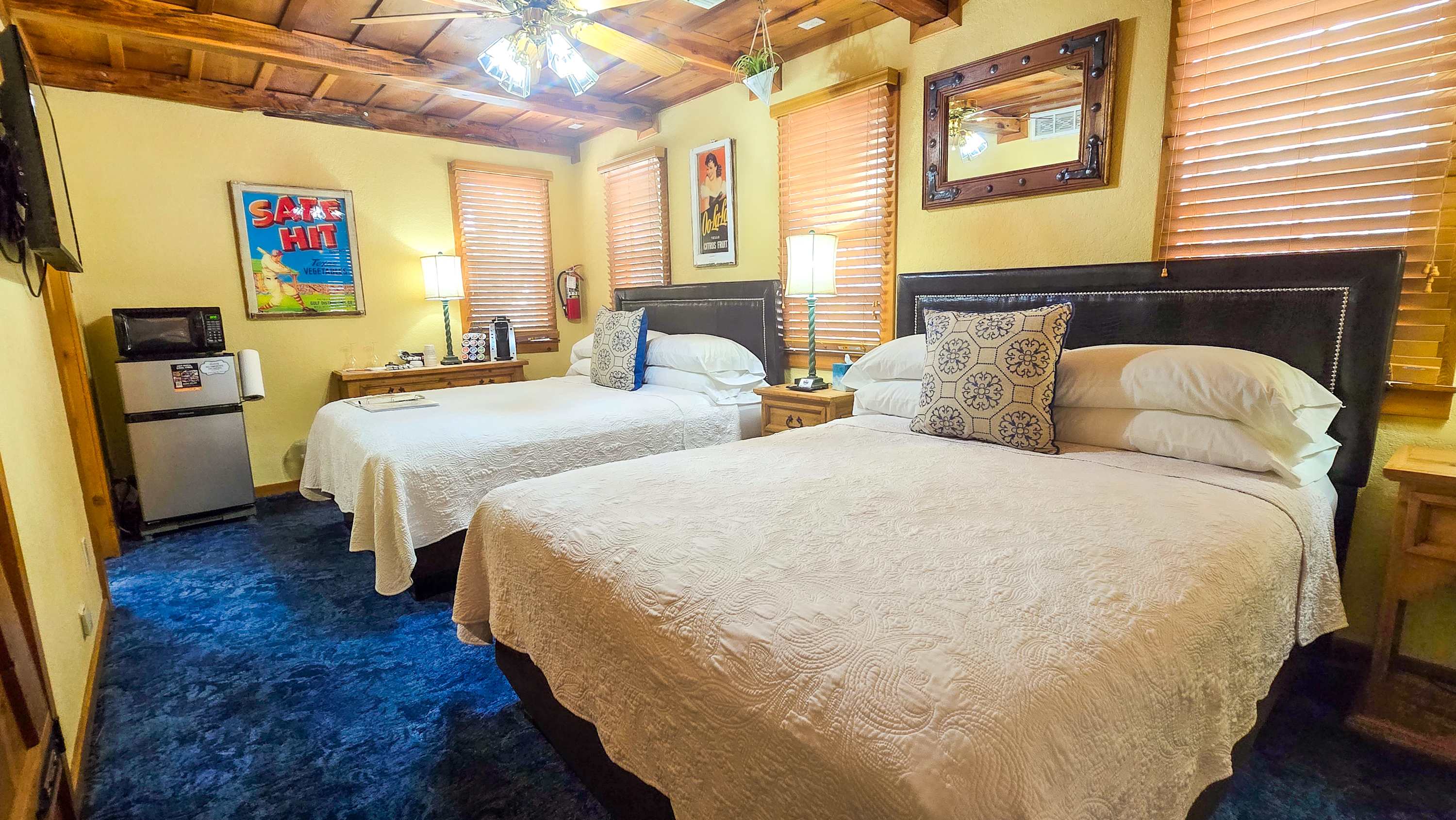 The bedroom area in Shiner Suite offers a pair of queen beds, a smart TV, & full bath​