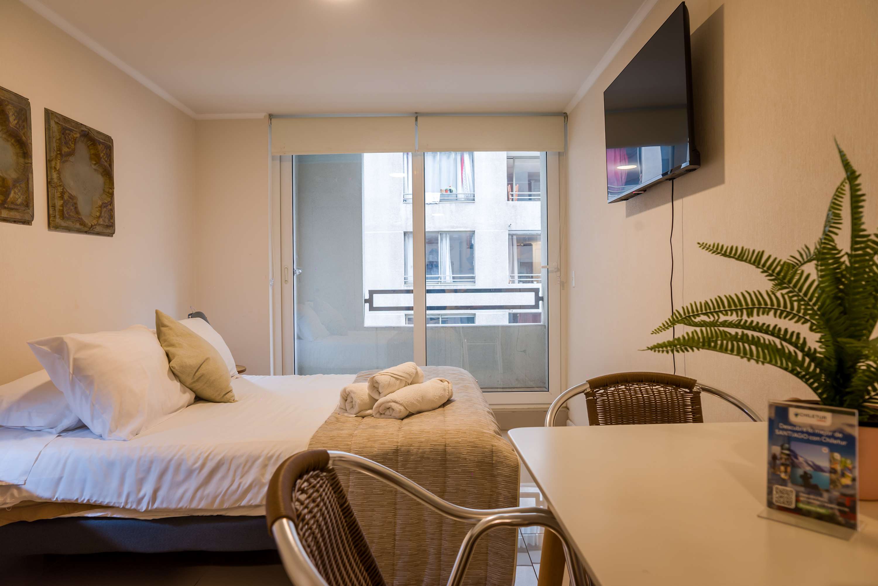 Cozy studio with a comfy bed, dining area, and balcony access, perfect for a relaxing stay in the heart of the city.