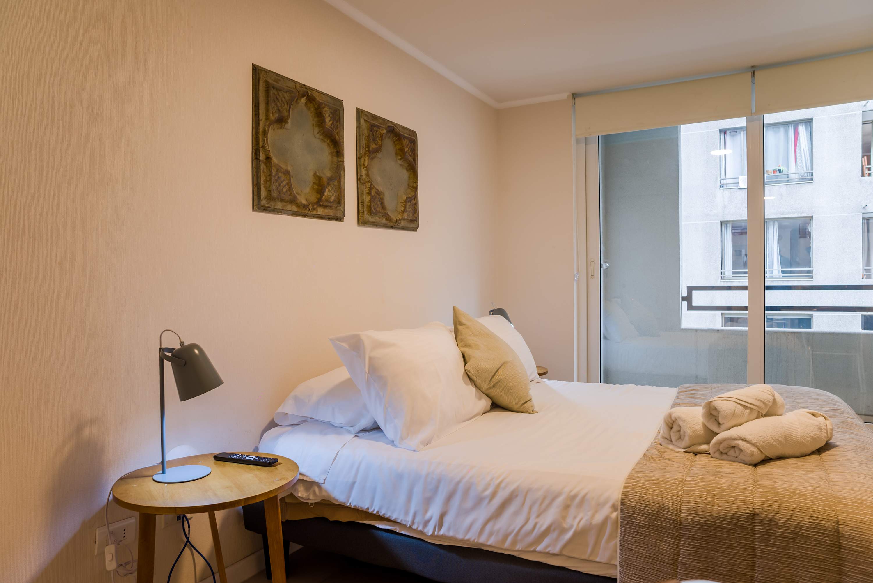 Relax in this cozy bedroom with natural light and modern decor, perfect for a restful stay in the heart of the city.