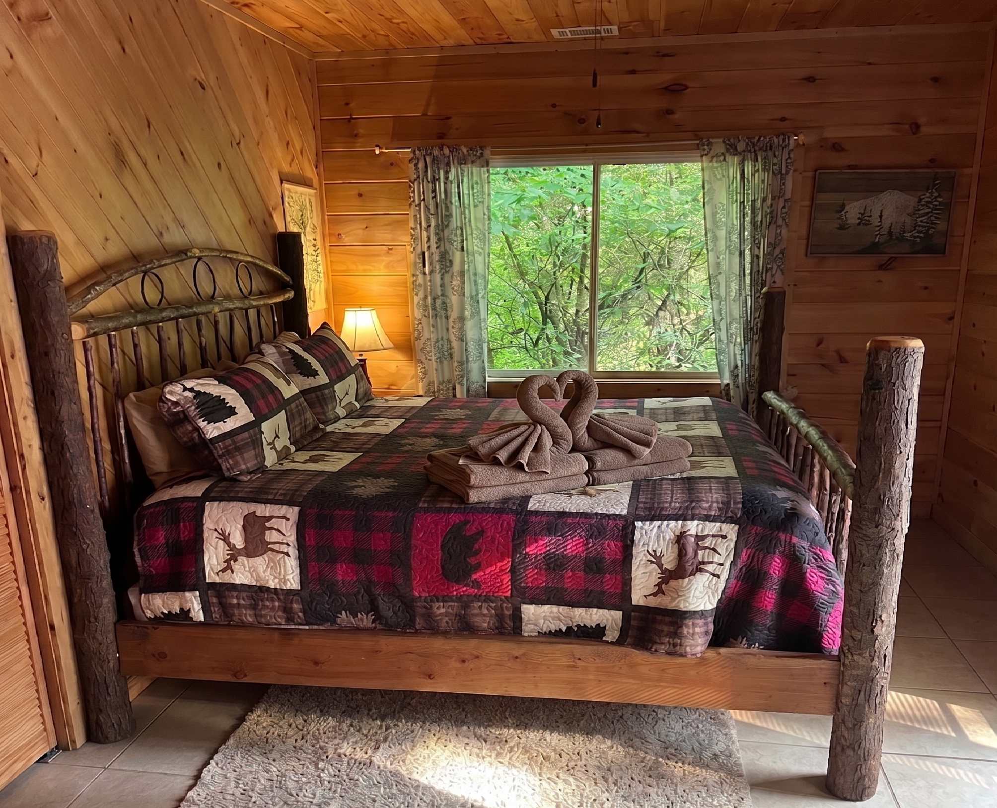 Relax in Bedroom 4 with a charming log bed and peaceful forest views.