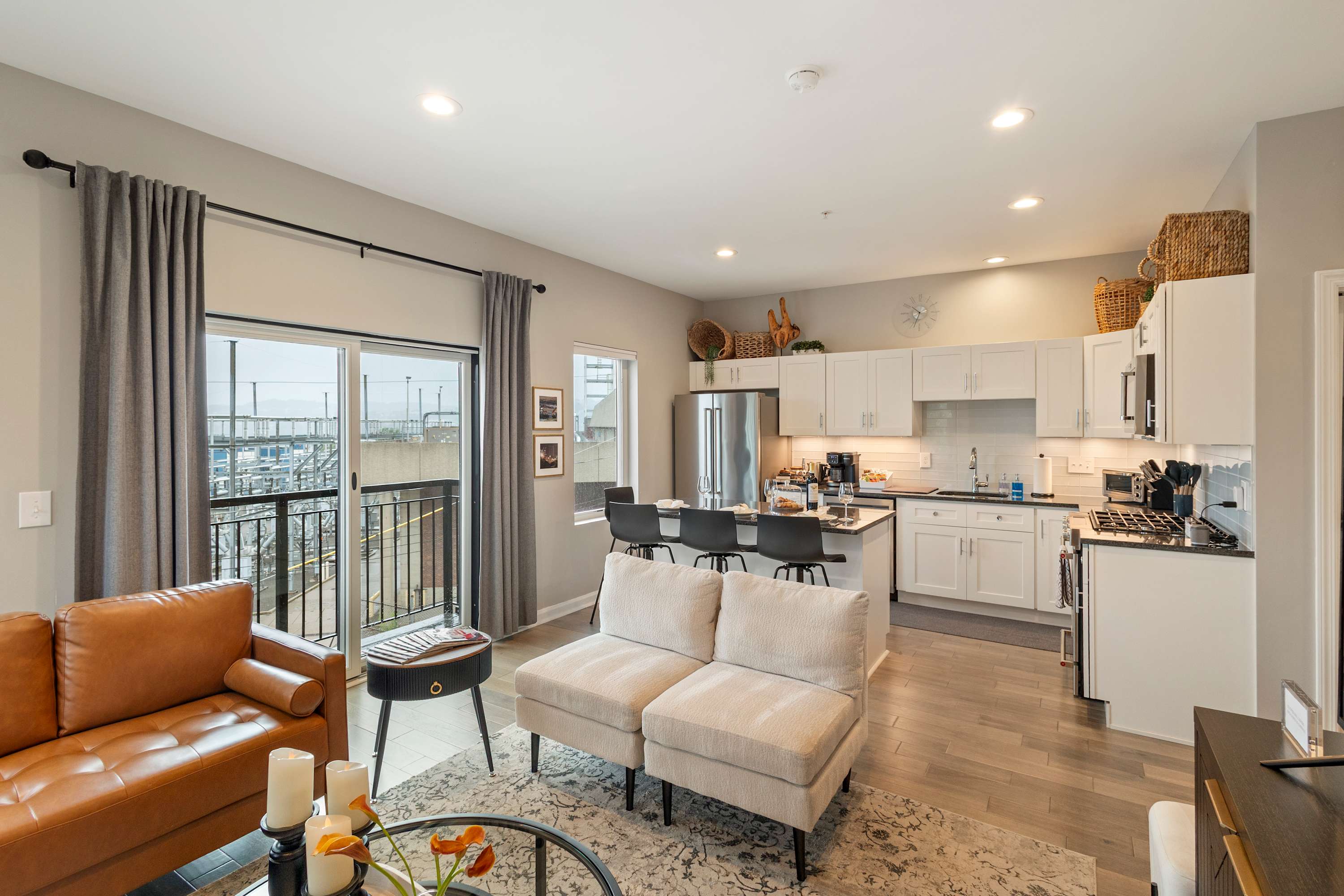Open concept living room and kitchen with views of the city, gourmet kitchen with brand new Kitchen Aid appliances, queen sleeper sofa in livingroom, 56" TV