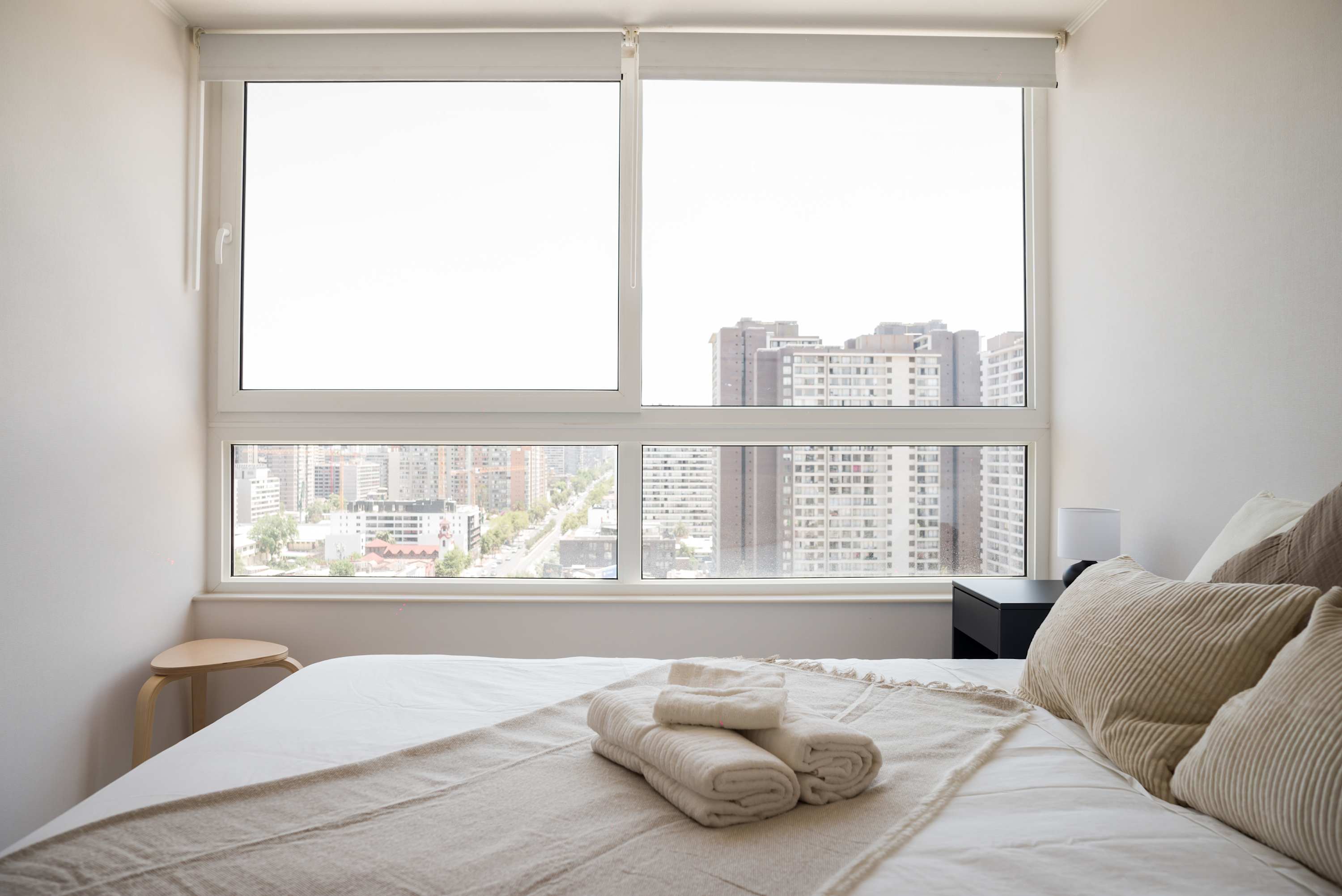 Relax in this serene bedroom with stunning city views, perfect for unwinding after a day of exploring.