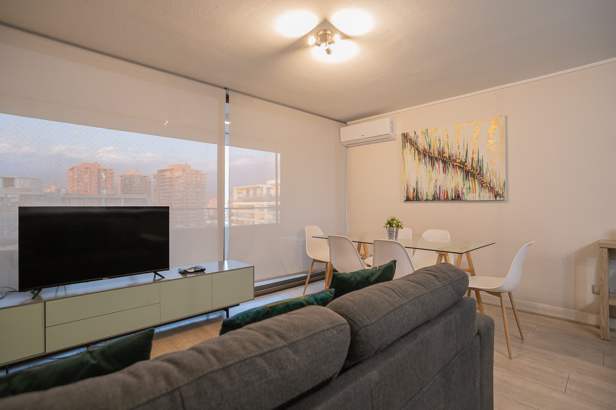 Modern living area with city views, perfect for relaxation and dining.