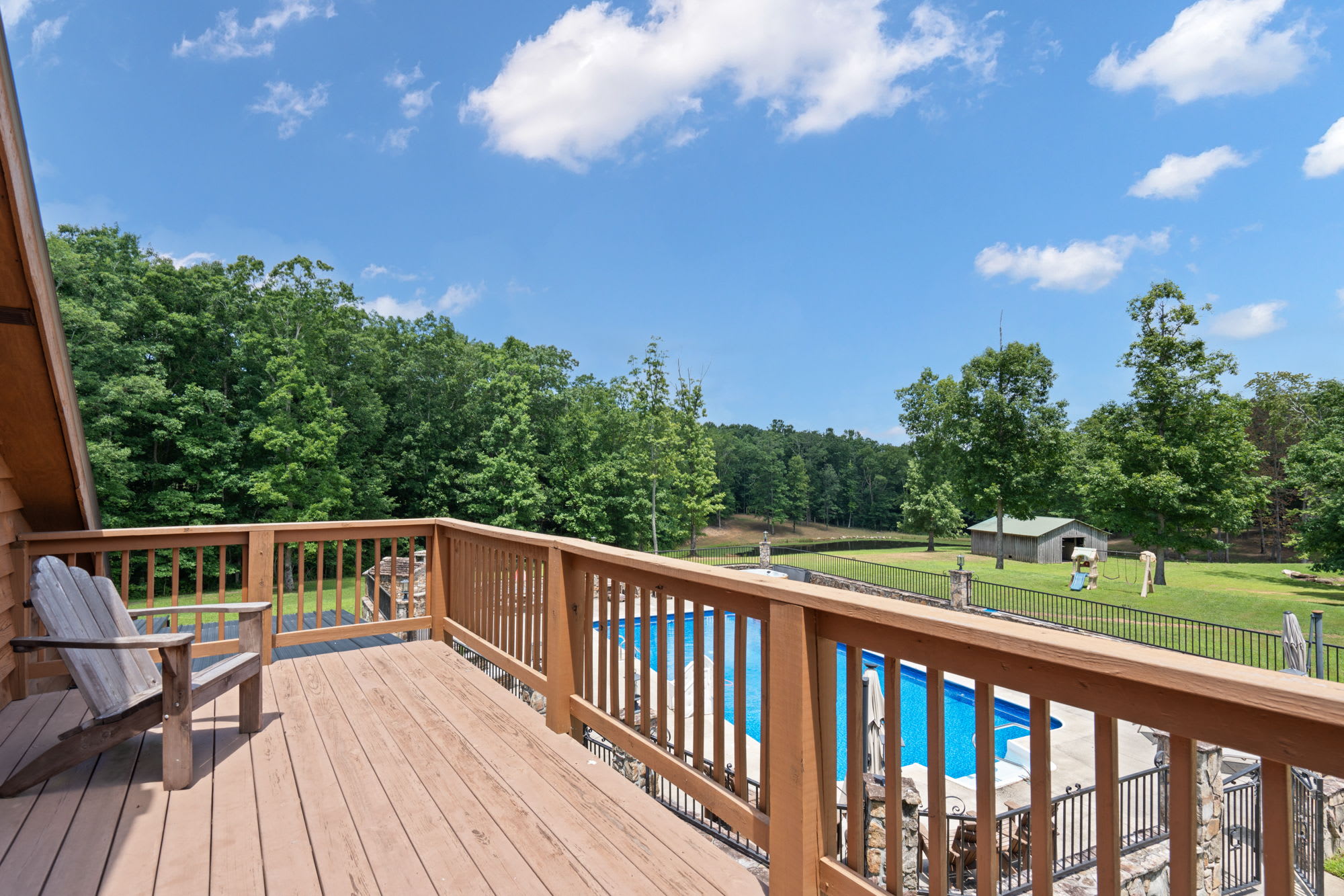 Upstairs bunk house entrance porch that overlooks the pool, one of the lakes, & the yard