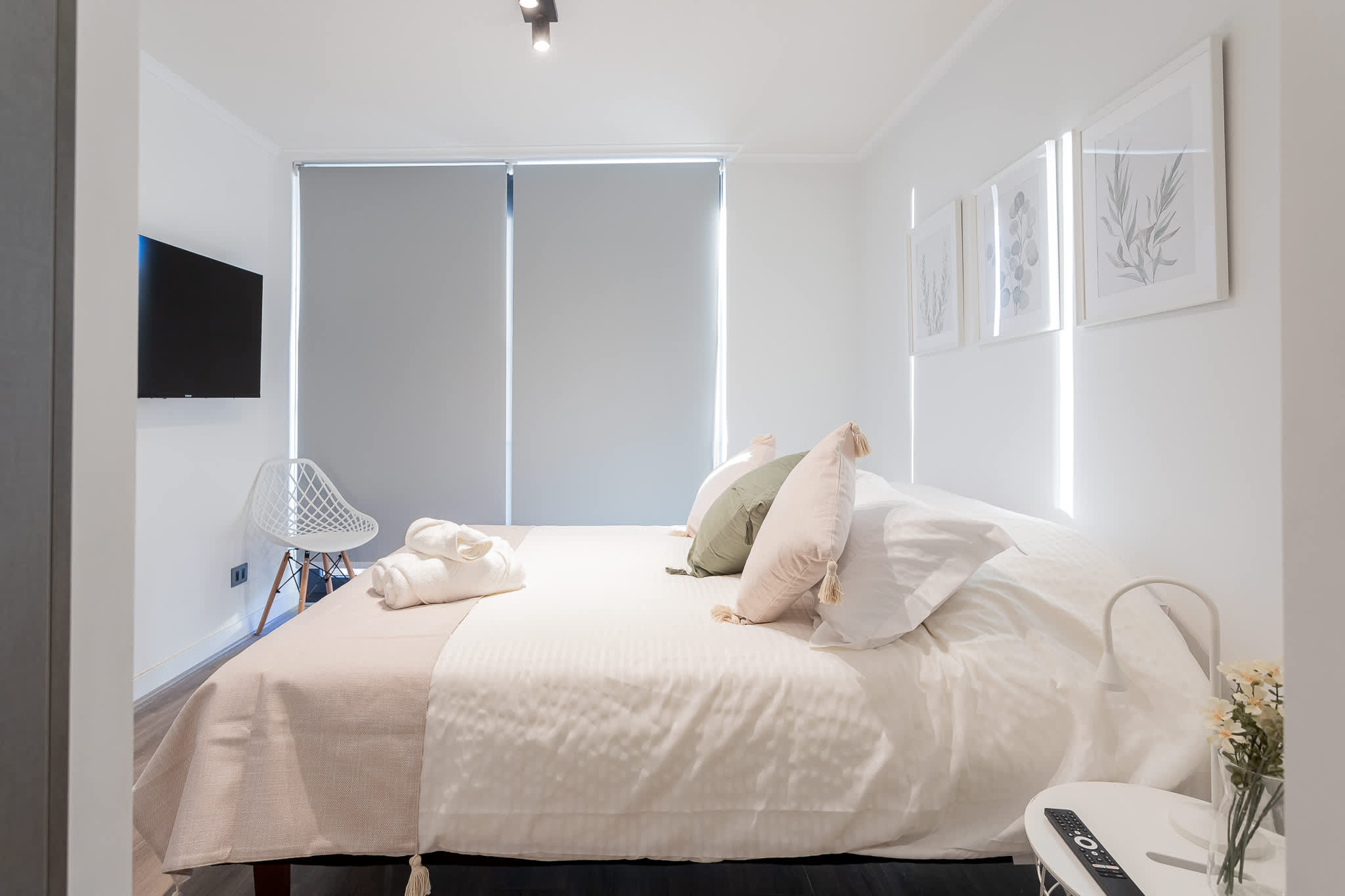 Relax in this cozy bedroom with modern decor, a comfortable bed, and a smart TV for your entertainment.