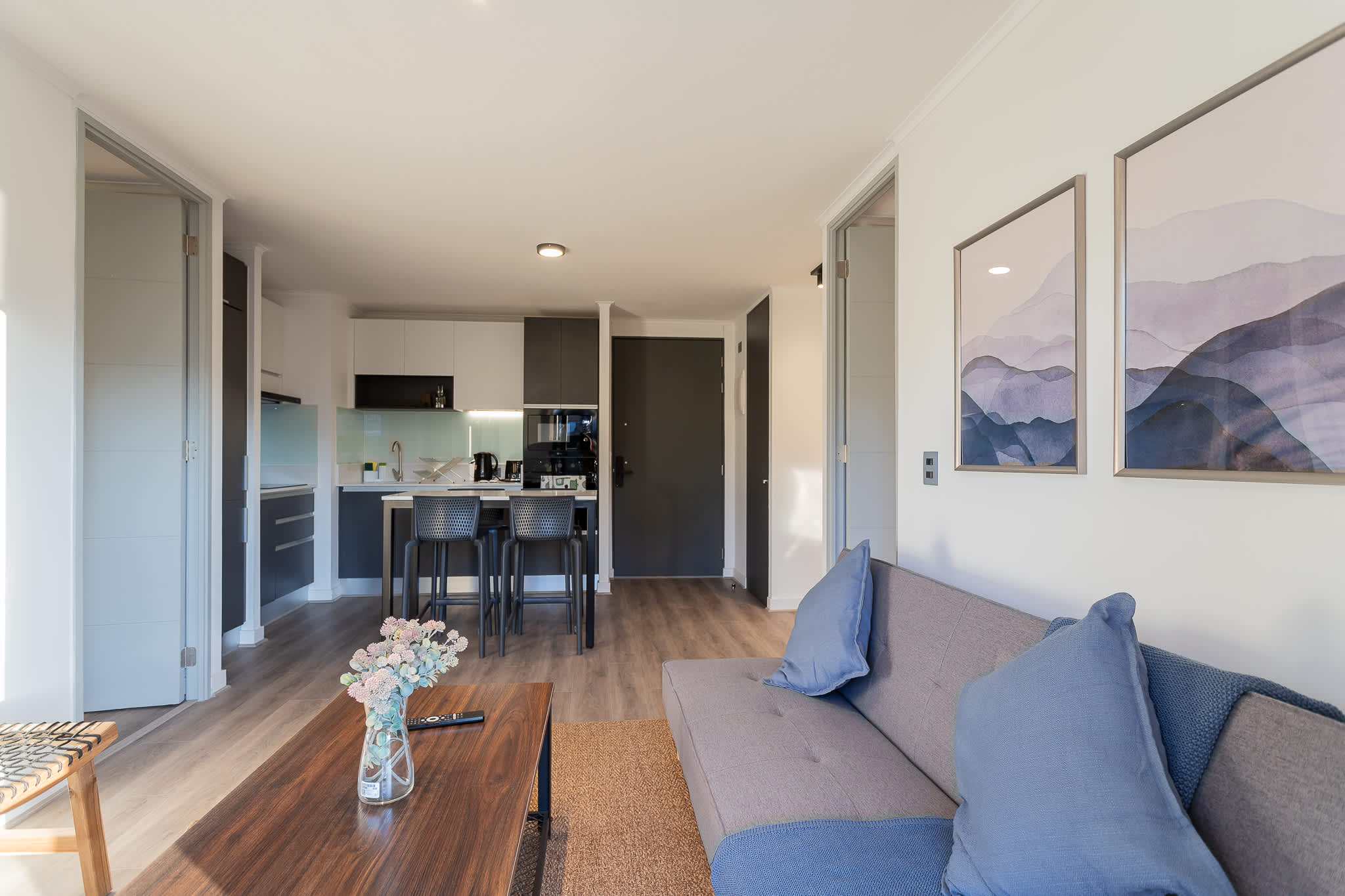 Bright and modern living area with a cozy sofa and a sleek kitchen, perfect for relaxing after a day of exploring.