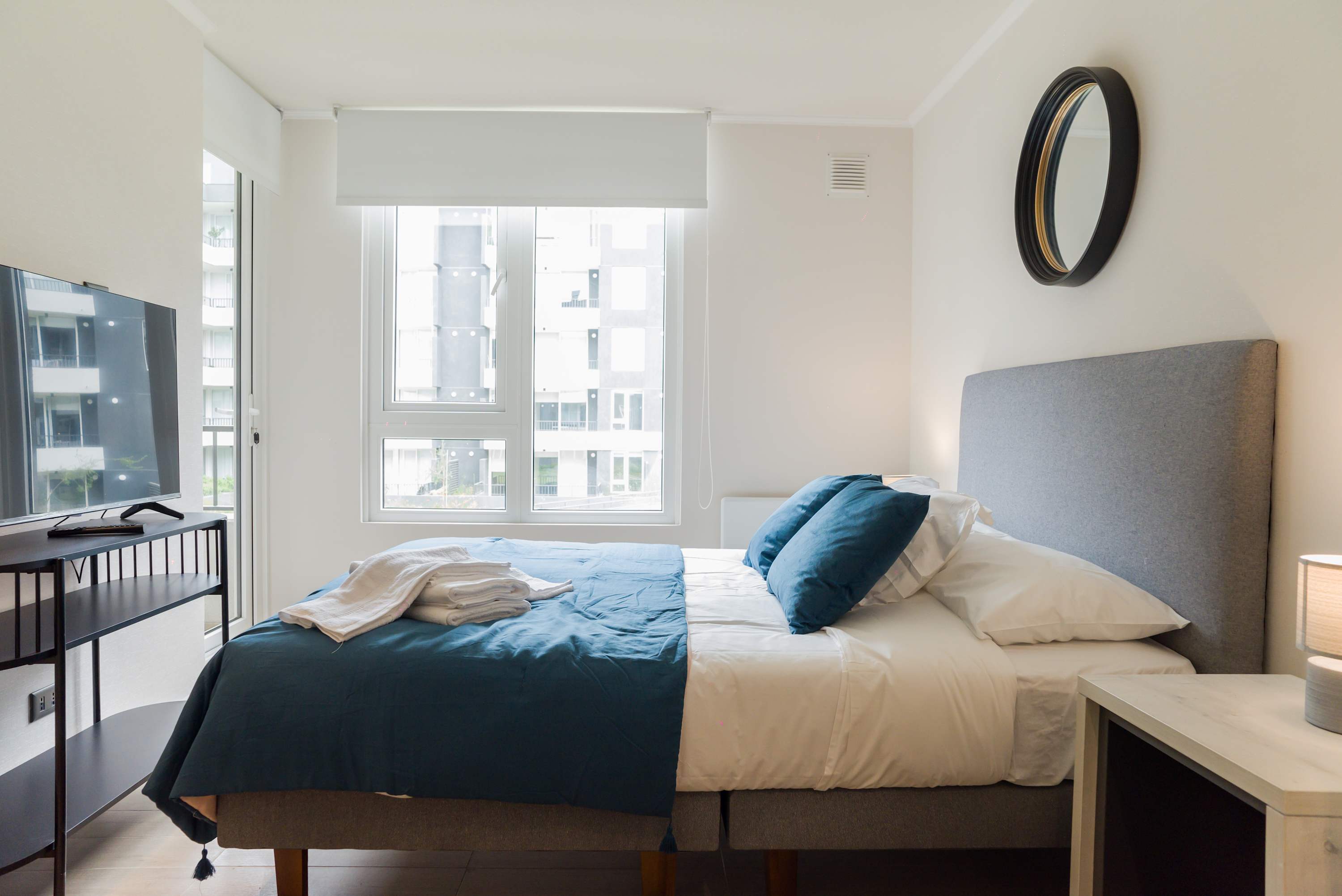 Bright and cozy bedroom with a comfortable bed and modern amenities, perfect for relaxation.