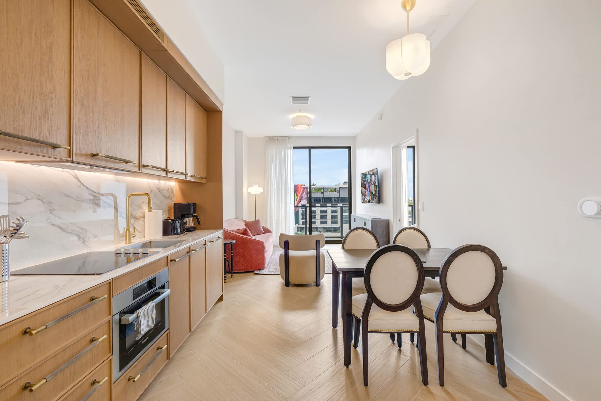 Modern studio kitchen with sleek design, dining area, and bright natural light, perfect for cozy meals and relaxation.