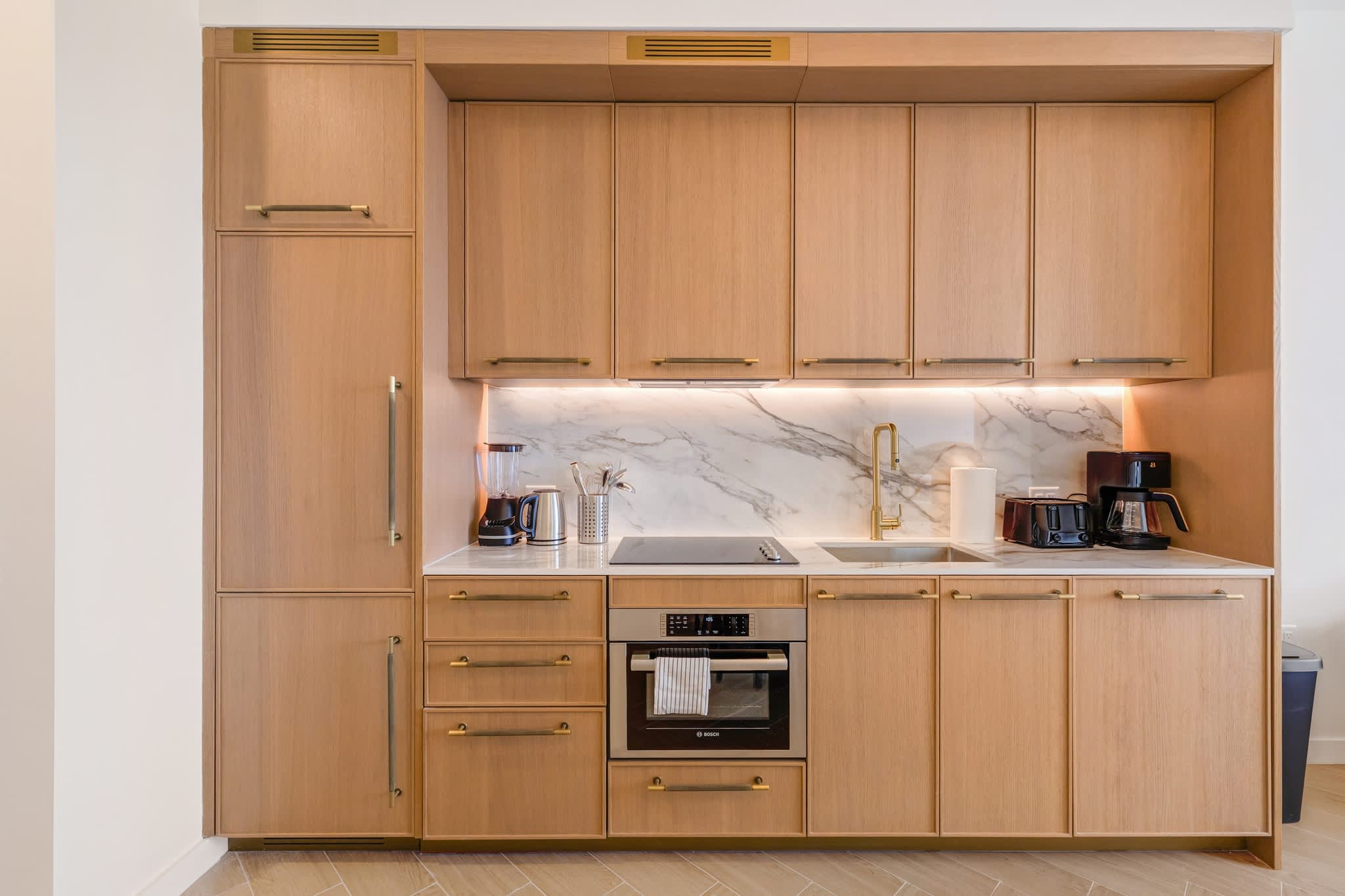 Sleek and modern kitchen with high-end appliances and elegant finishes, perfect for cooking and dining in style.