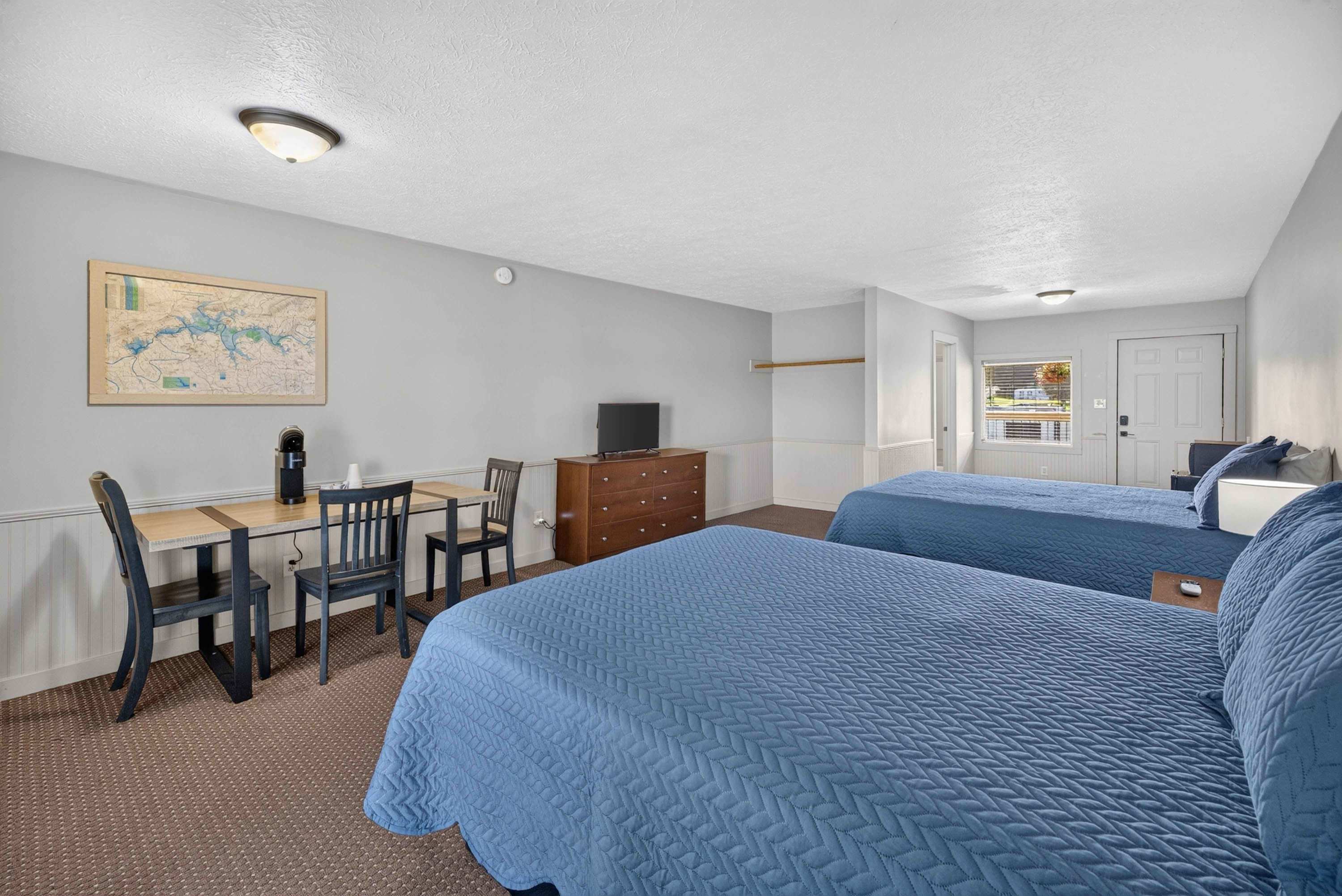 Coffee maker, TV, dresser, two queen beds, & table with chairs