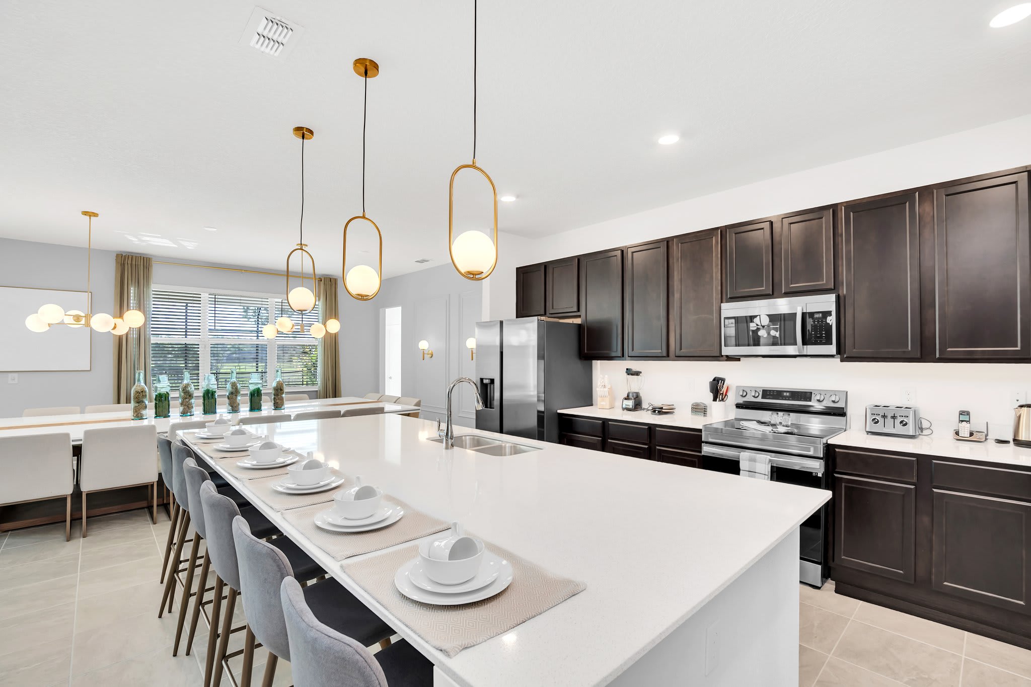 Experience culinary delight in this expansive, modern kitchen with ample seating and sleek design, perfect for hosting large gatherings.