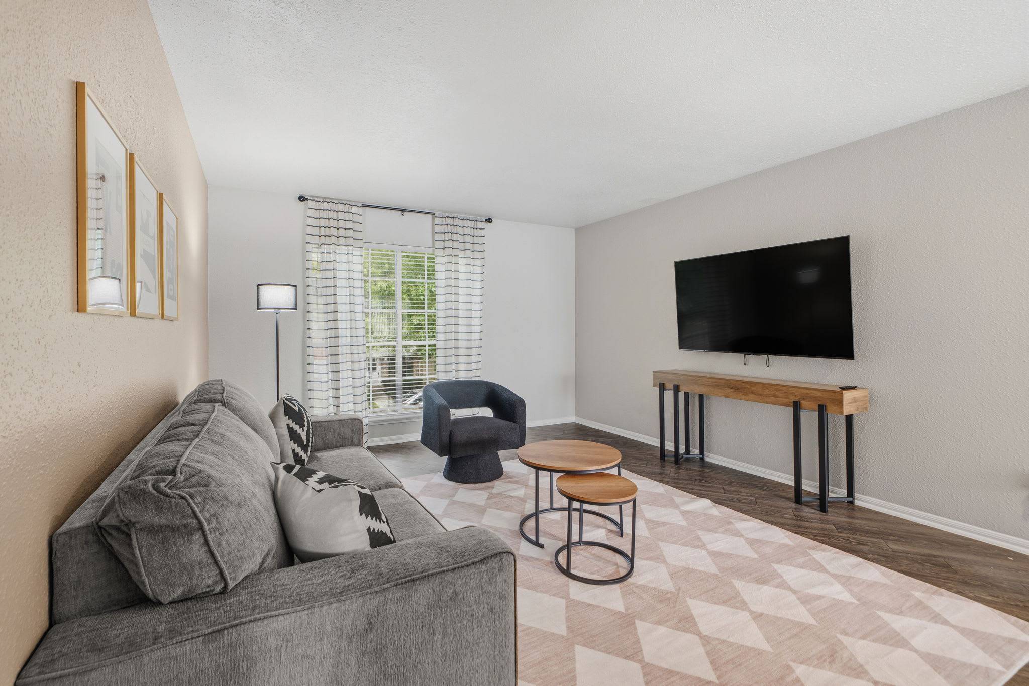 Relax in this stylish living room with a cozy sofa, modern decor, and a large TV for entertainment.