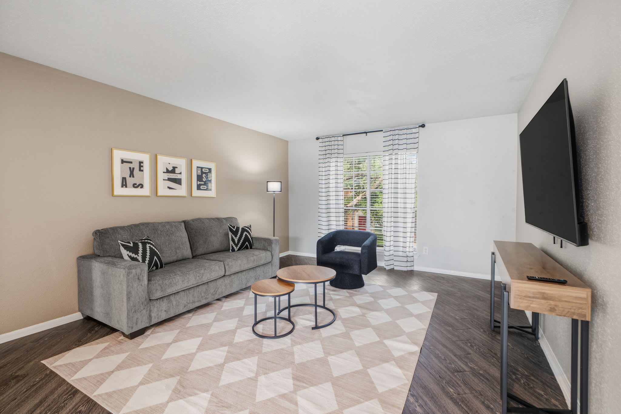 Relax in this stylish living room with a comfy sofa, modern decor, and a large TV for entertainment.