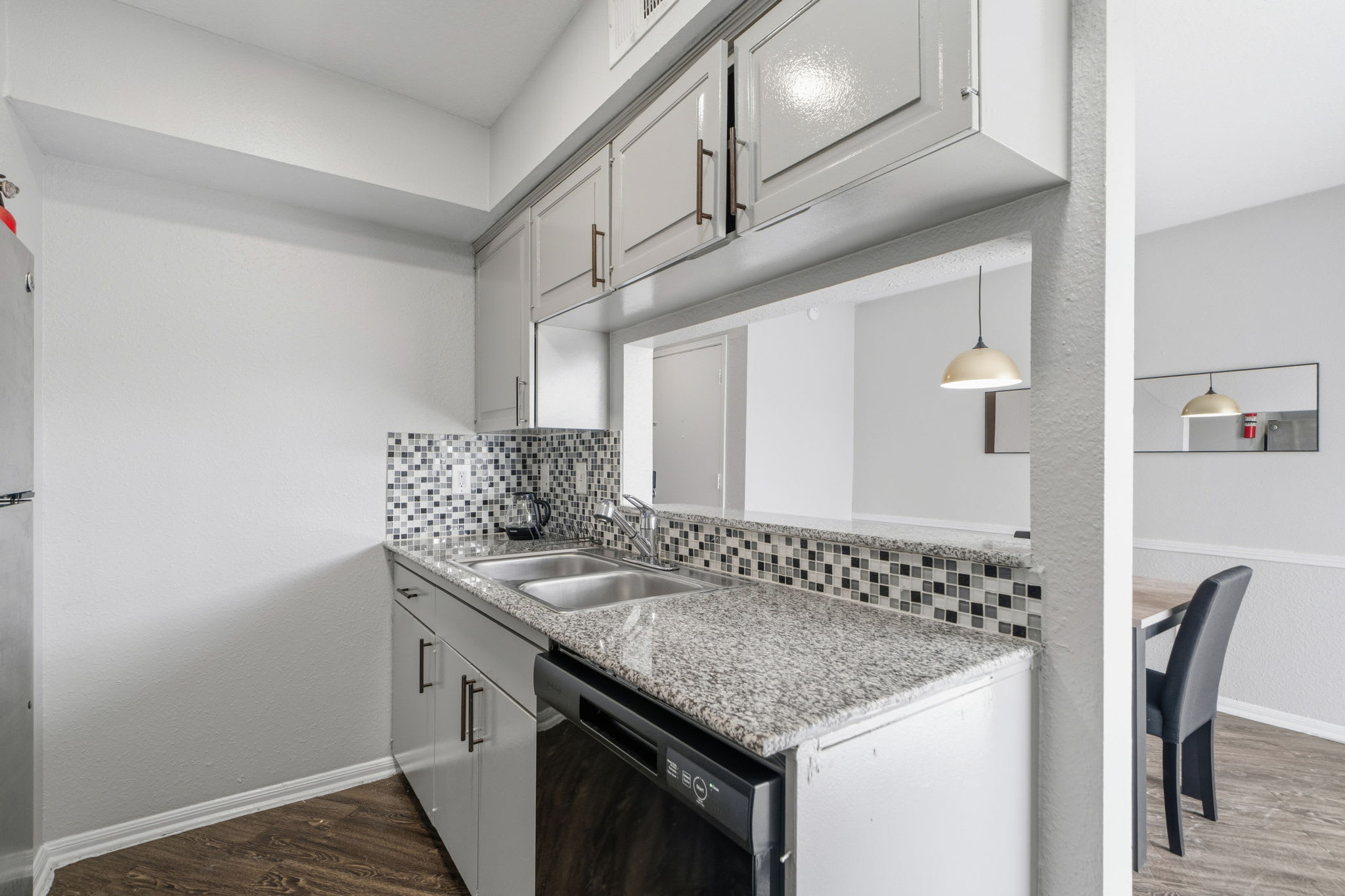 Modern kitchen with sleek granite countertops and stylish backsplash, perfect for culinary adventures.