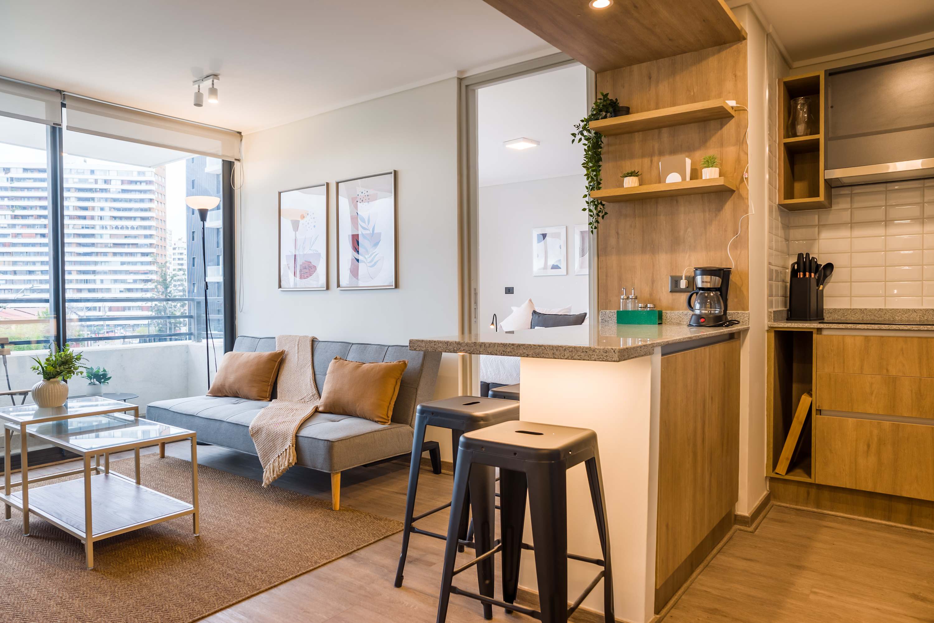 Modern living space with cozy seating and a well-equipped kitchen, perfect for relaxation and dining.