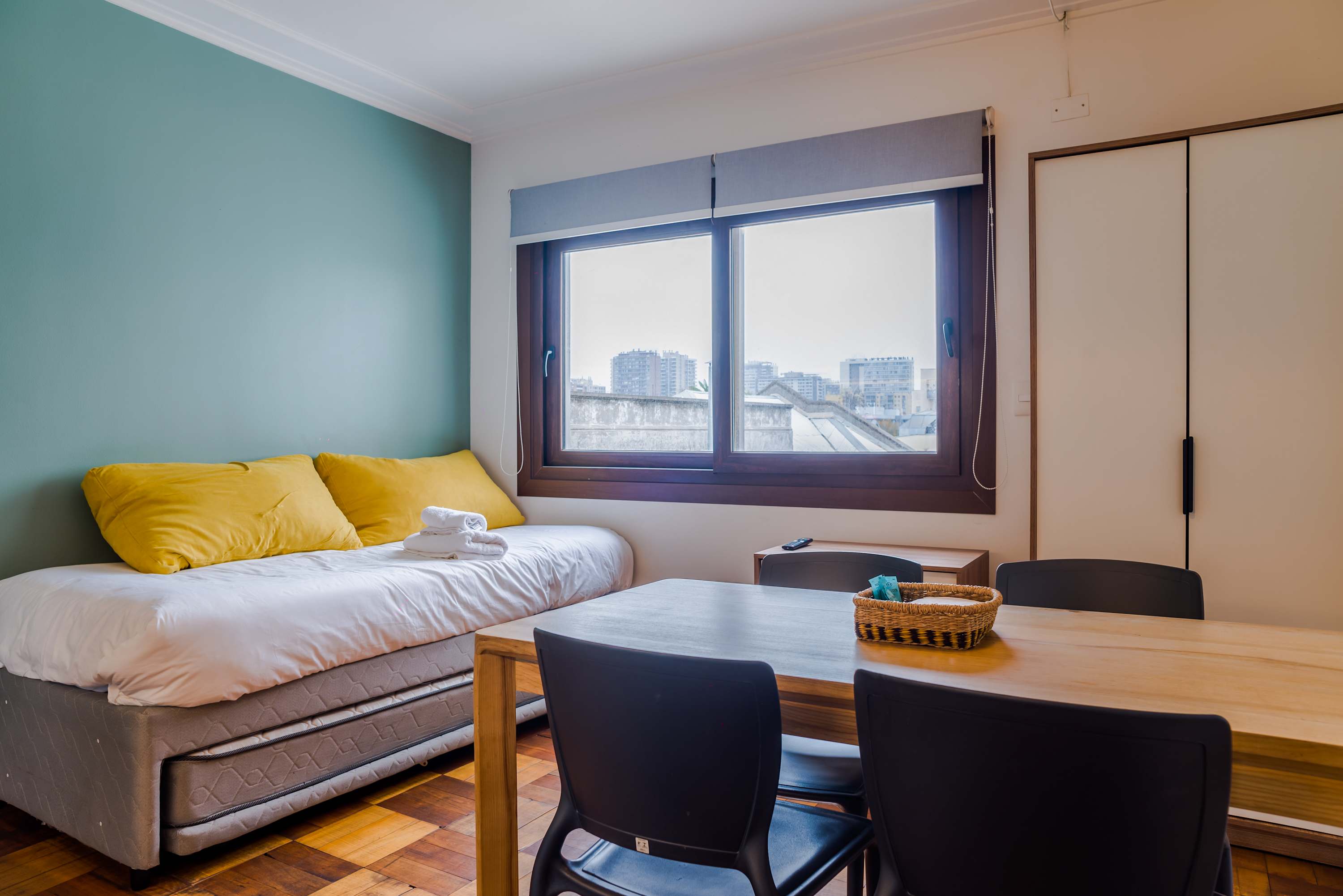 Cozy studio with city views, featuring a comfortable bed and dining area, perfect for a relaxing stay.