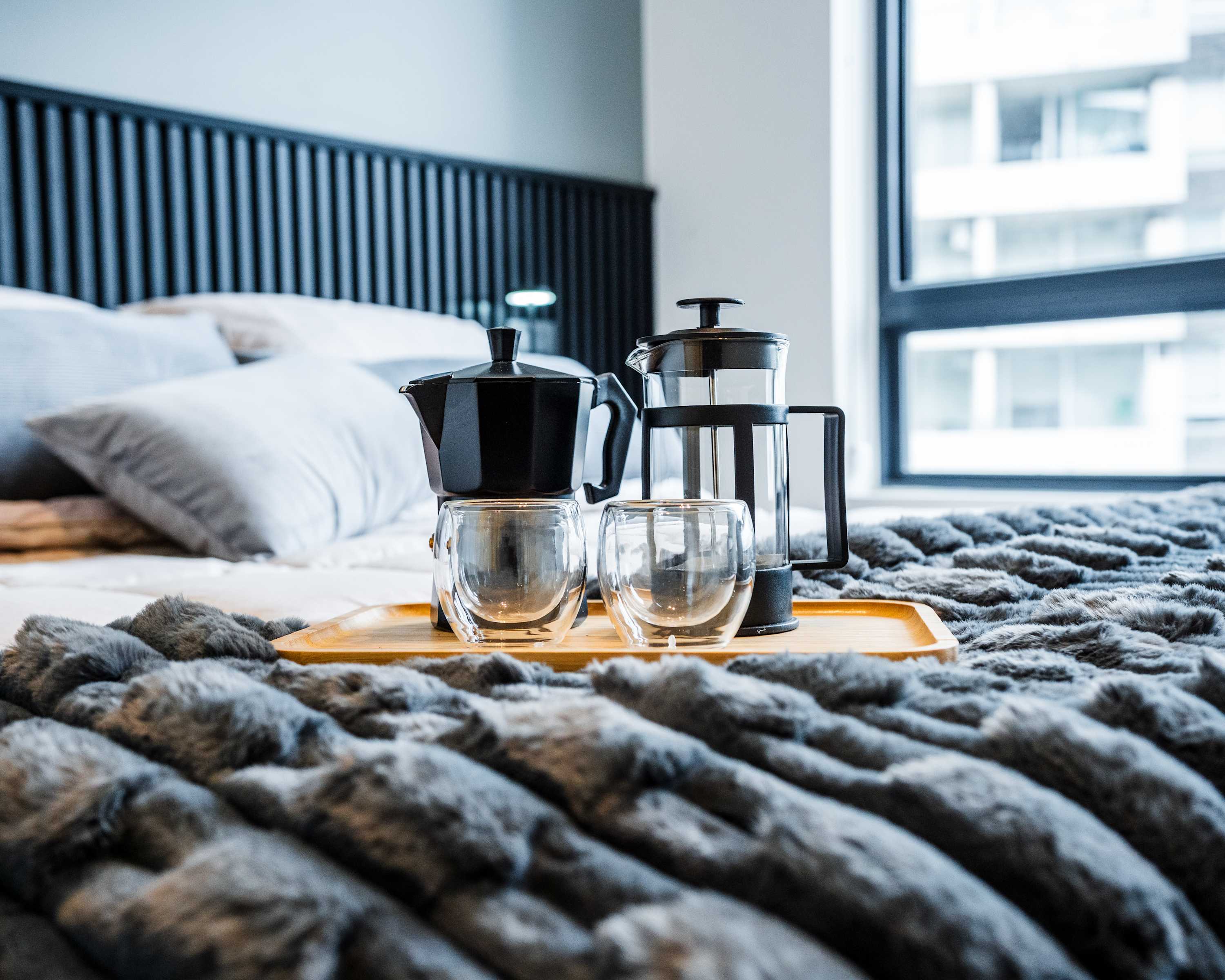 Relax in a cozy bedroom with a plush blanket and enjoy a fresh brew from the in-room coffee maker.