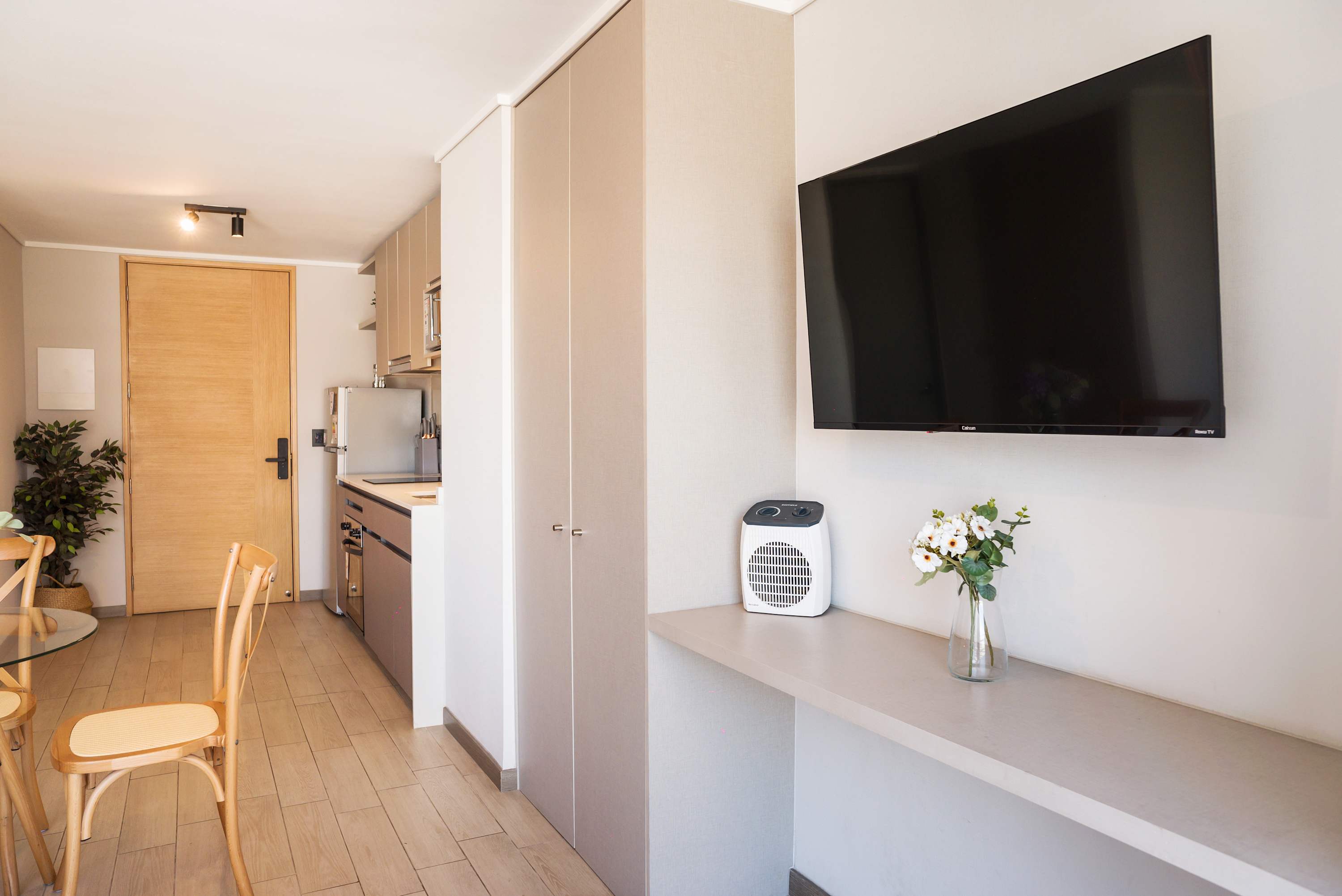 Modern studio kitchen with sleek appliances and cozy dining space, perfect for a comfortable stay.