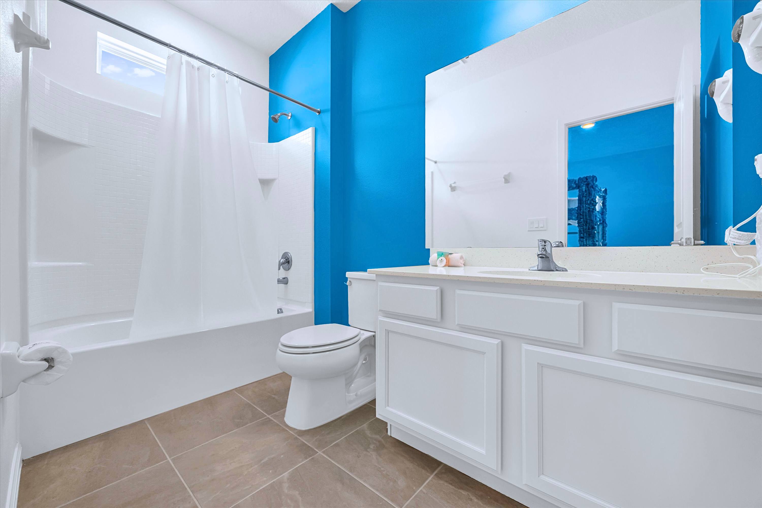 Private en-suite bathroom featuring a bathtub shower combo, sink vanity, mirror & toilet