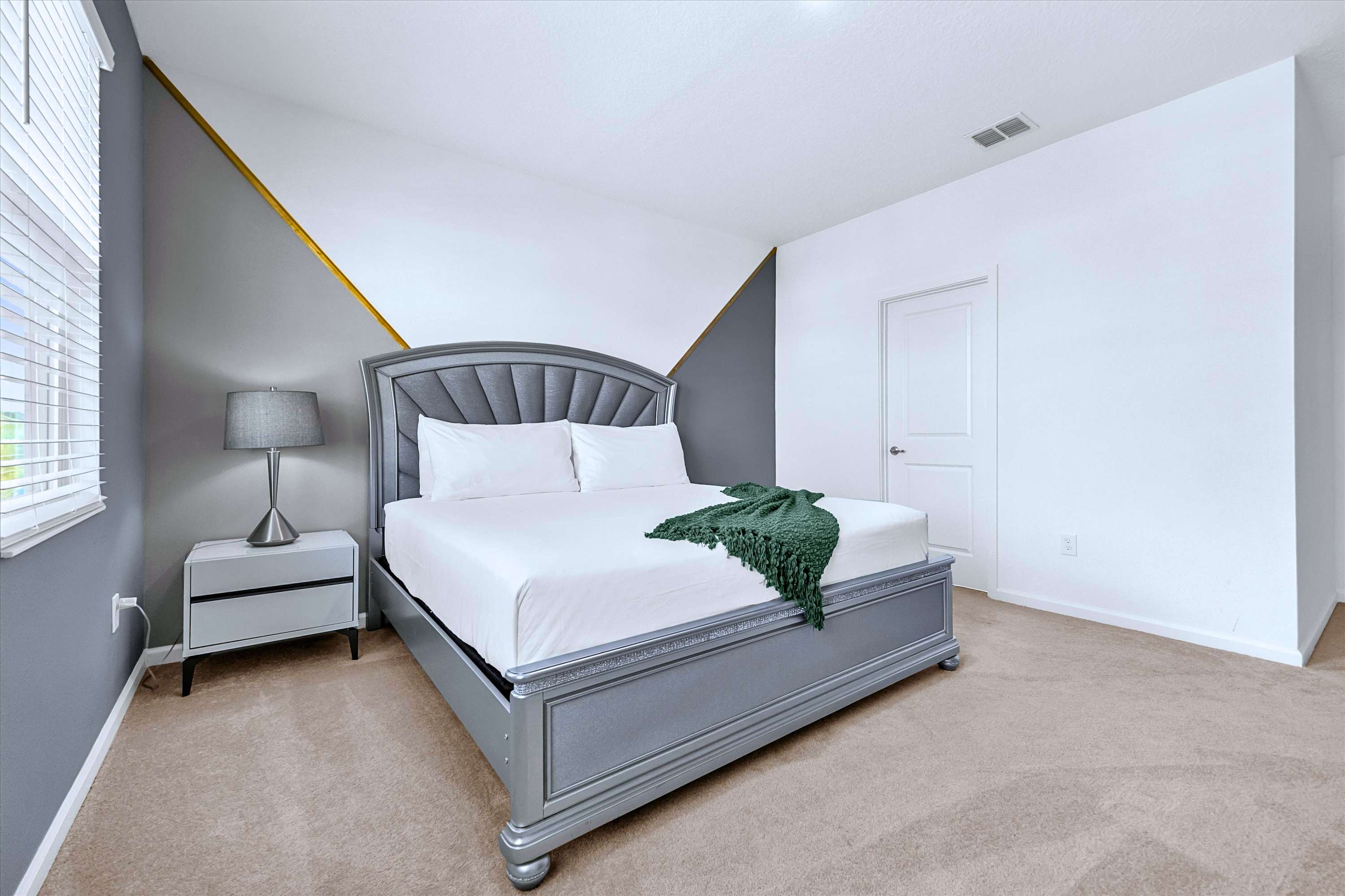 King Bed suite with premium hotel linens, headboard, reading lamp, and private en-suite bathroom
